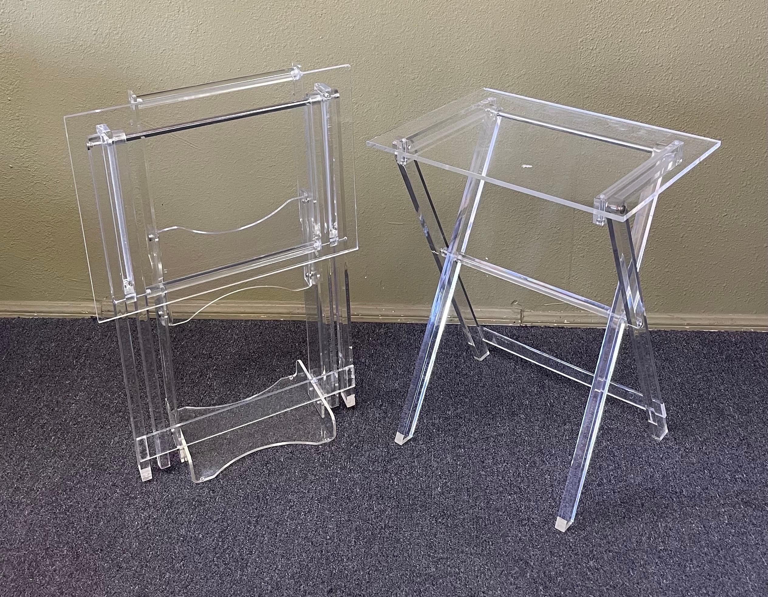 A very nice set (stand and two tray tables) of MCM lucite folding TV trays / tray tables, circa 1970s. The set is in good vintage condition with some minor crazing and scratches to the lucite; on the stand, the set measures 19,75