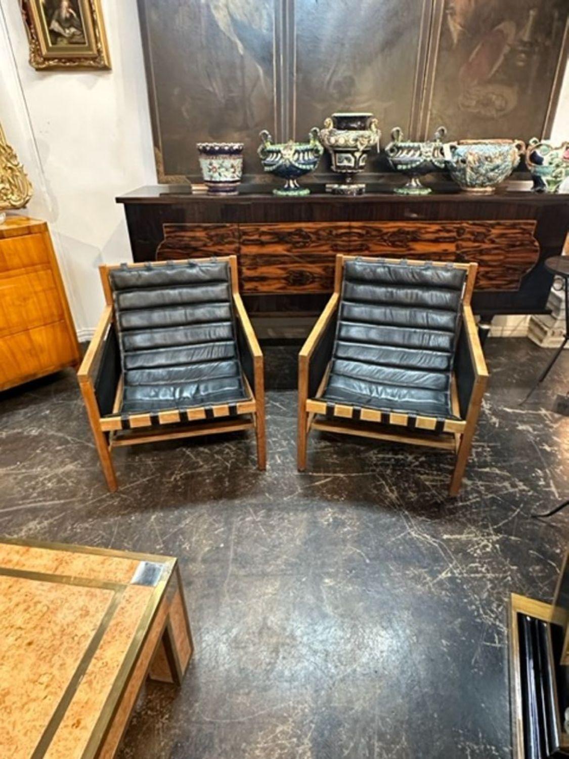 Great pair of MCM oak and leather arm chairs with magazine slats, circa 1960. Perfect for today's transitional designs!