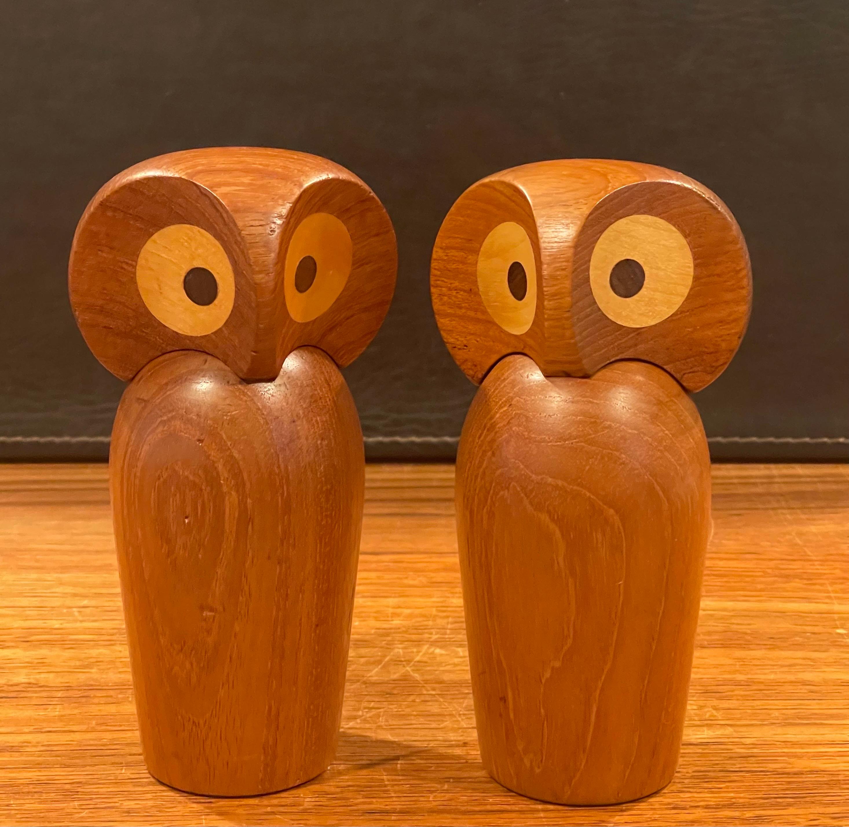 Rare pair of MCM teak owl sculptures with posable heads by Skjode Skjern of Denmark, circa 1950s. The owls are finely crafted and made of teak with walnut and oak inset eyes. The head is seperate piece and can rotate like a real owl. The set is in