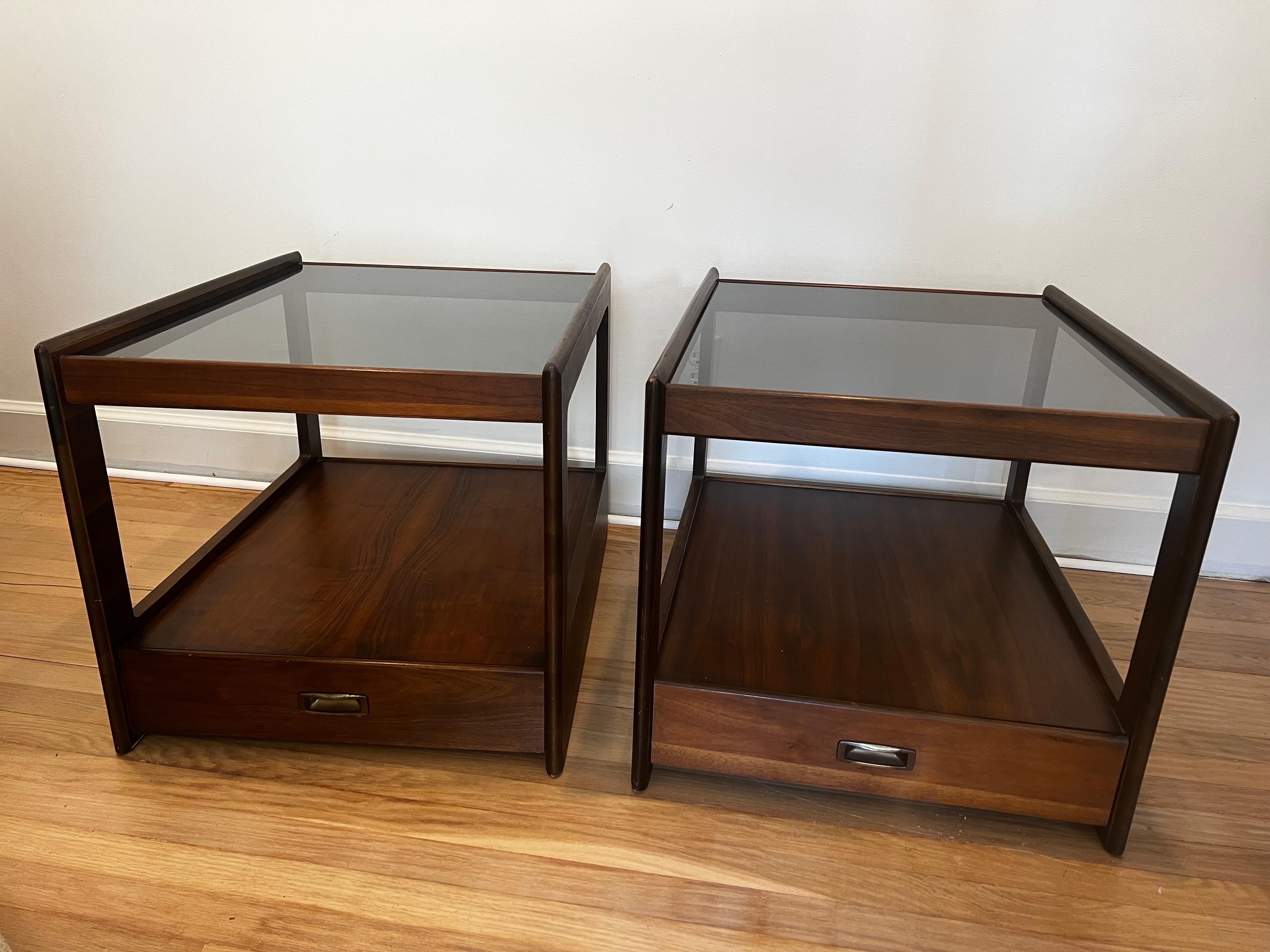 Pair of sophisticated streamlined single end tables in the style of John Keal for Saltman Brown.   Walnut with smoked glass tops. 
Drawers open and close smoothly.

*Matching coffee table available.   See other listing.   