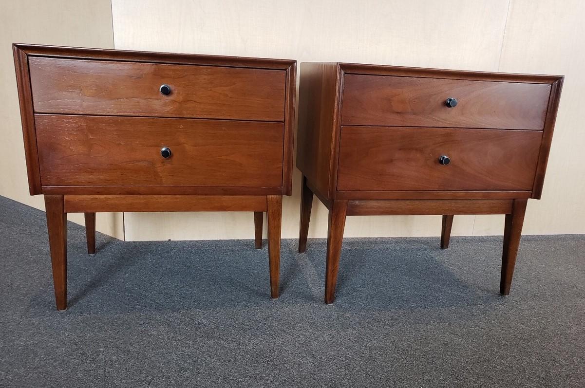 Gorgeous pair of Mid-Century Modern American walnut double drawer nightstands by American of Martinsville, circa 1960s. 

Great lines and functional design featuring two drawers and black metal pulls. Unsure of designer, but this is a very rare