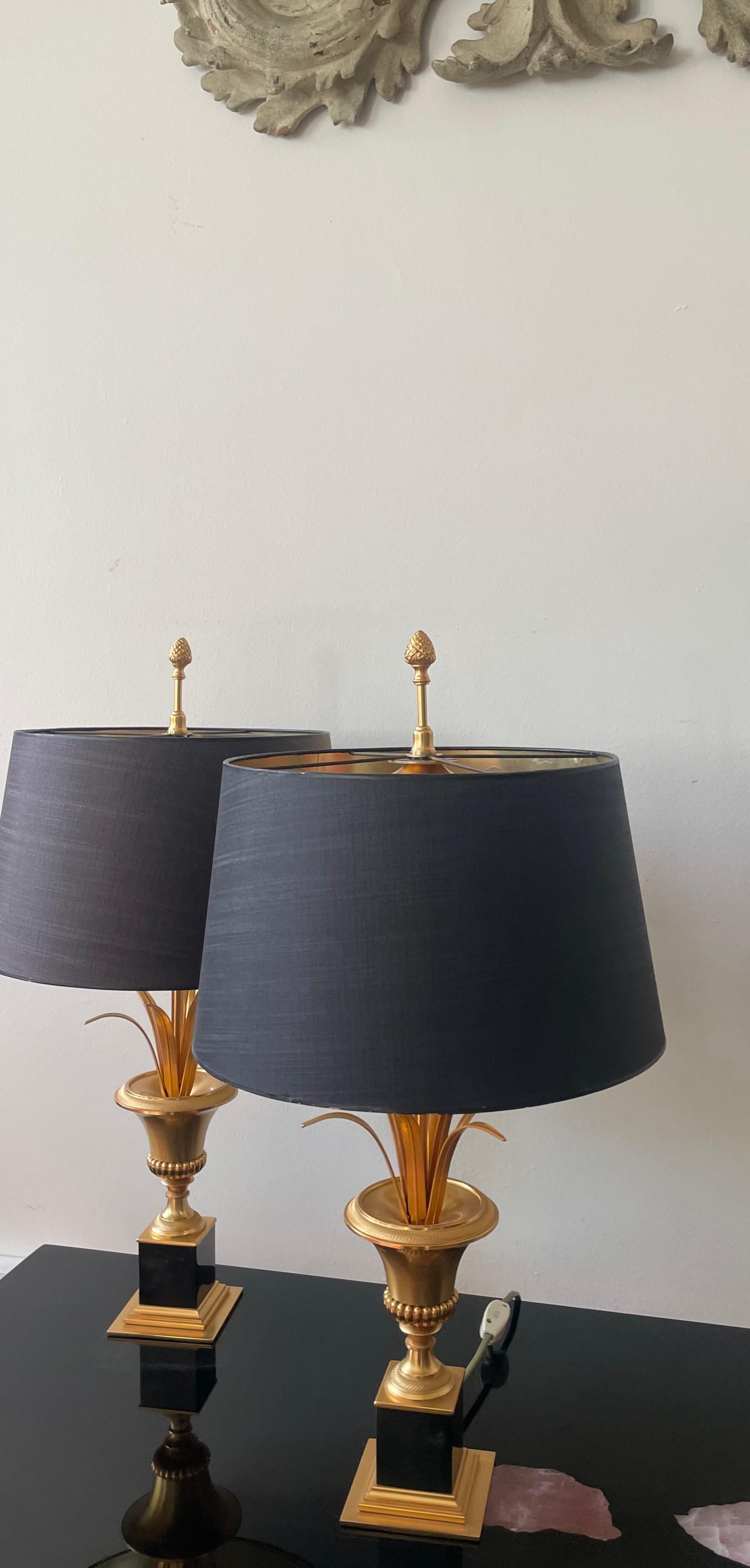 Elegant pair of neoclassical brass table lamps with original black silk lampshades.
The interior of the lampshades is gold leaf.
The lamps presenting a Medicis urn with a palmtree.
Attributed to Maison Charles, Paris 1960.