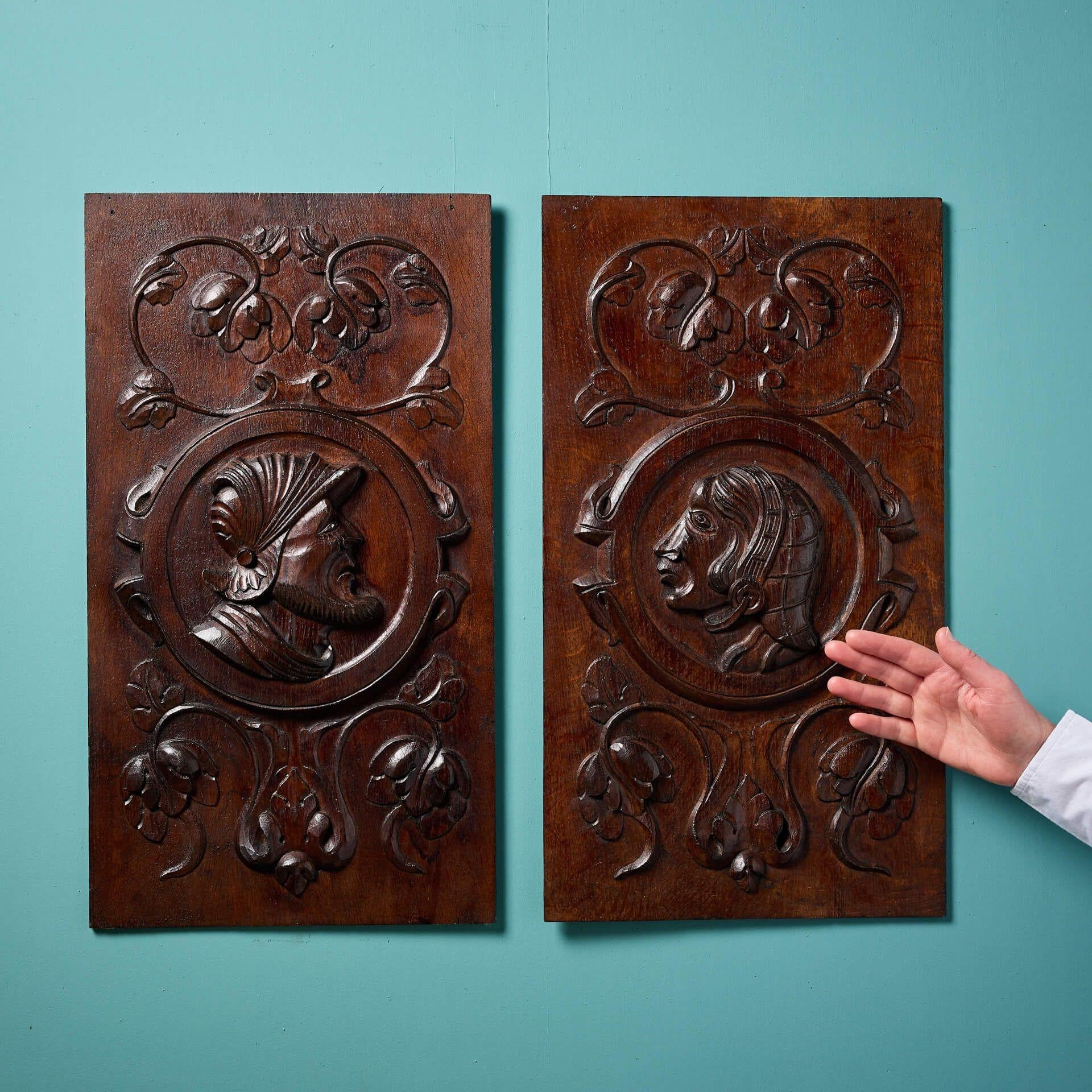 A pair of antique English handcarved oak panels depicting nobles in medieval and Jacobean styles, circa 1850. 
 
Each of an expert quality after more than 170 years, these wall panels both depict a bust of a male and female noble figures encircled