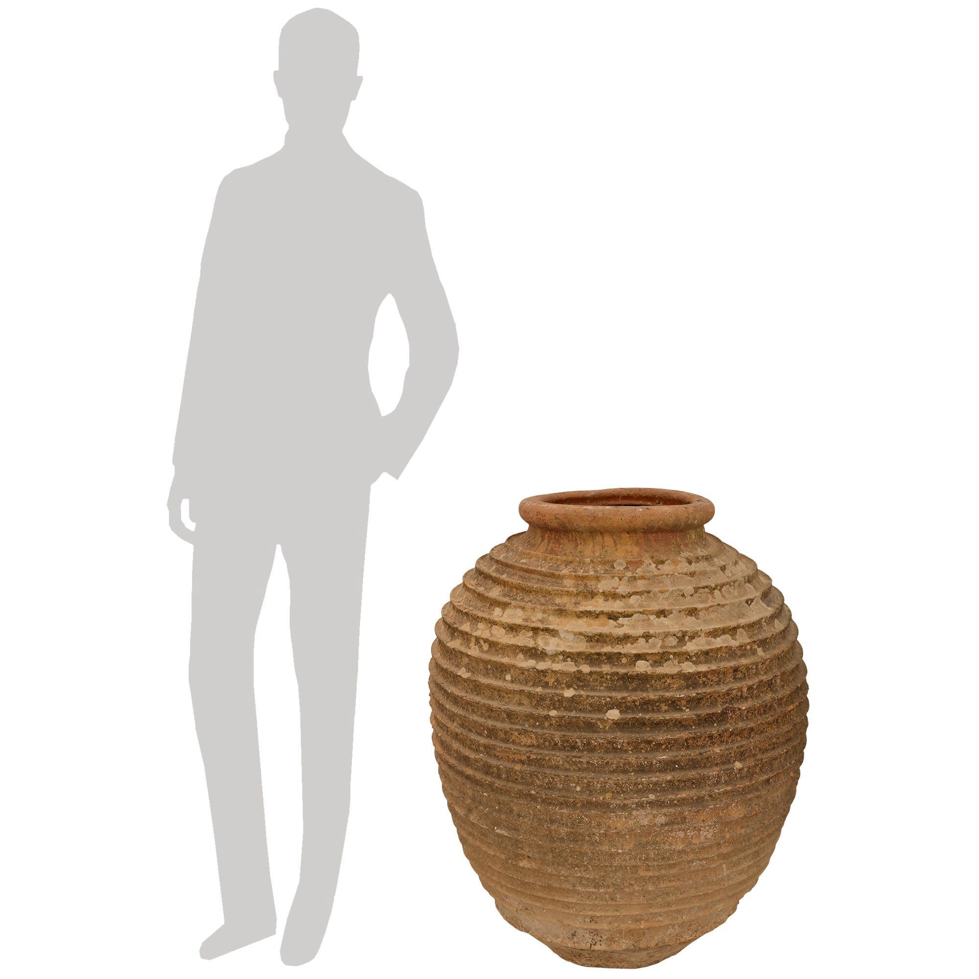 Una bella e affascinante coppia di vasi per olive in terracotta del XIX secolo. Ogni vaso di oliva dalla forma elegante mostra delle belle fasce avvolgenti con nervature che conducono al bordo superiore screziato con uno smalto marrone molto