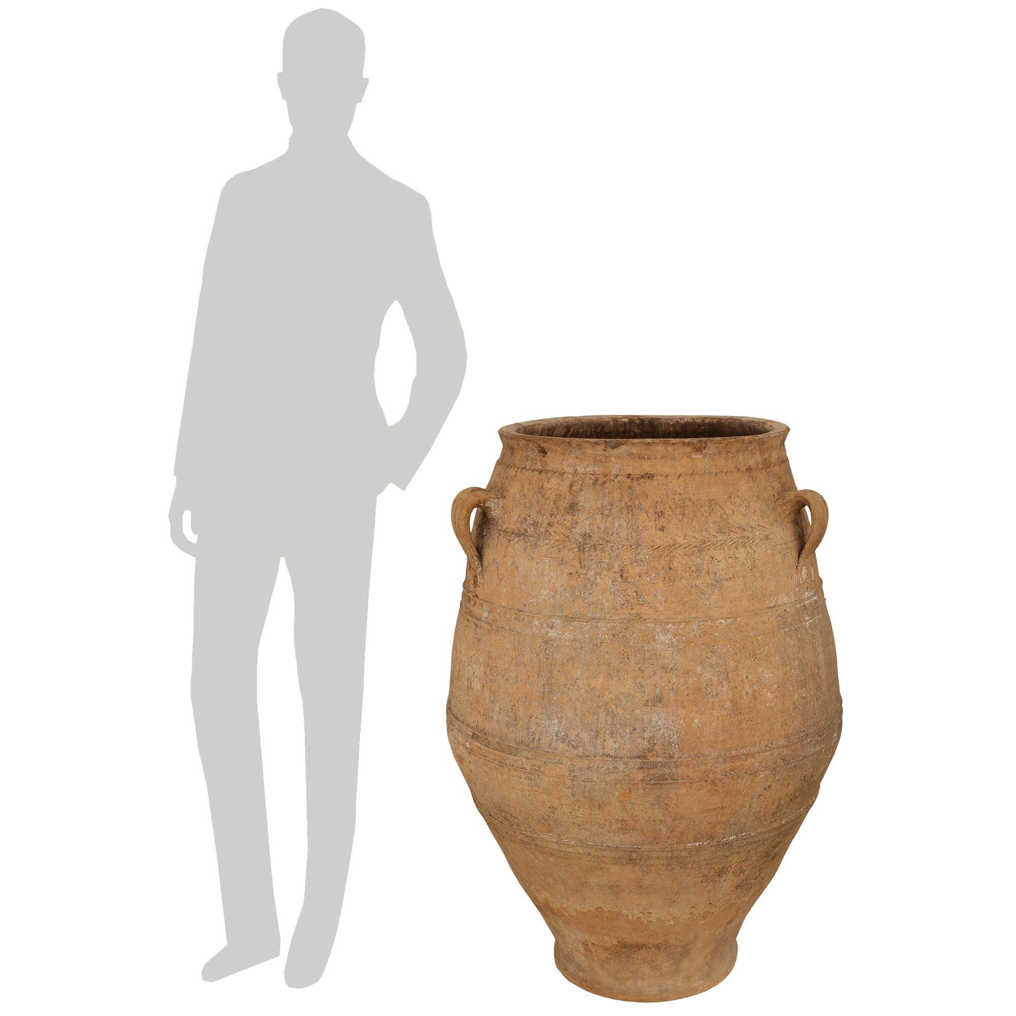 Magnifique paire de jarres à olives en terre cuite du XIXe siècle. Chaque pot à olives, magnifique et extrêmement décoratif, présente une forme de balustre incurvée des plus élégantes, avec trois anses à volutes au-dessus, et une patine d'origine