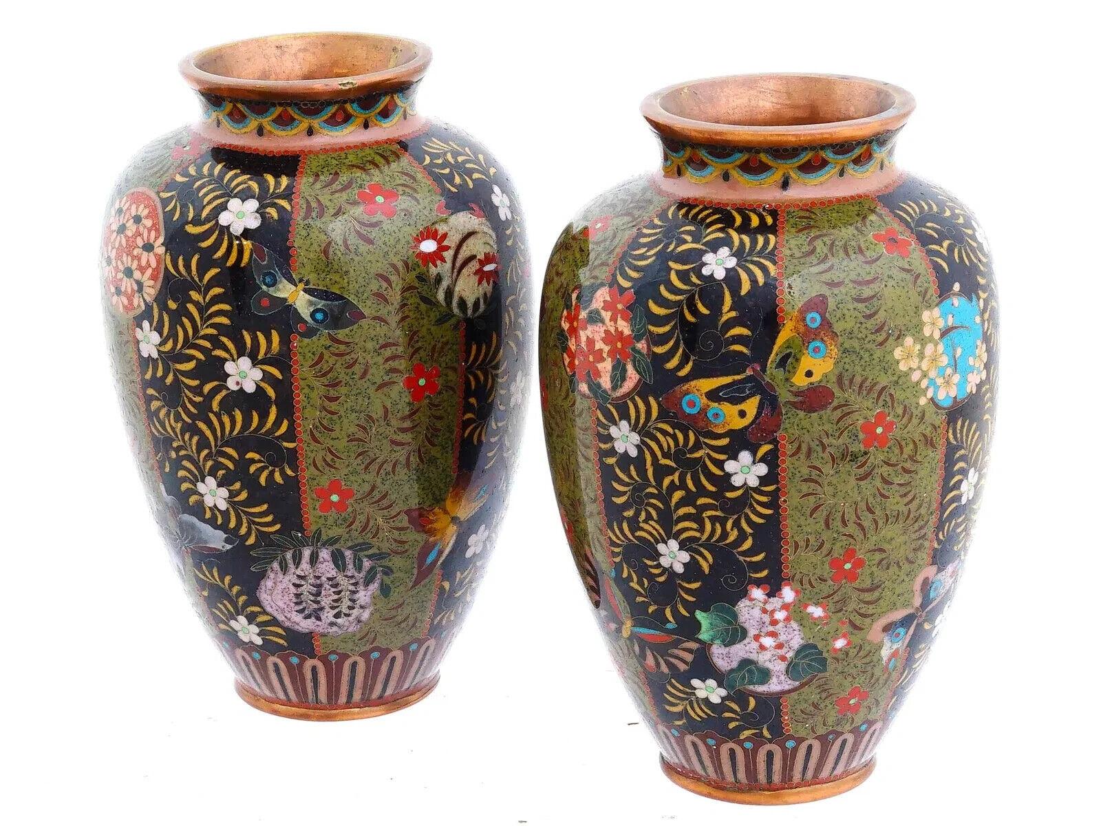 Pareja de antiguos jarrones japoneses de esmalte cloisonné en forma de balaustre, cada uno con un diseño a rayas multicolor realzado con motivos florales, follaje y mariposas. El vibrante trabajo de esmalte está enmarcado por bordes exteriores de