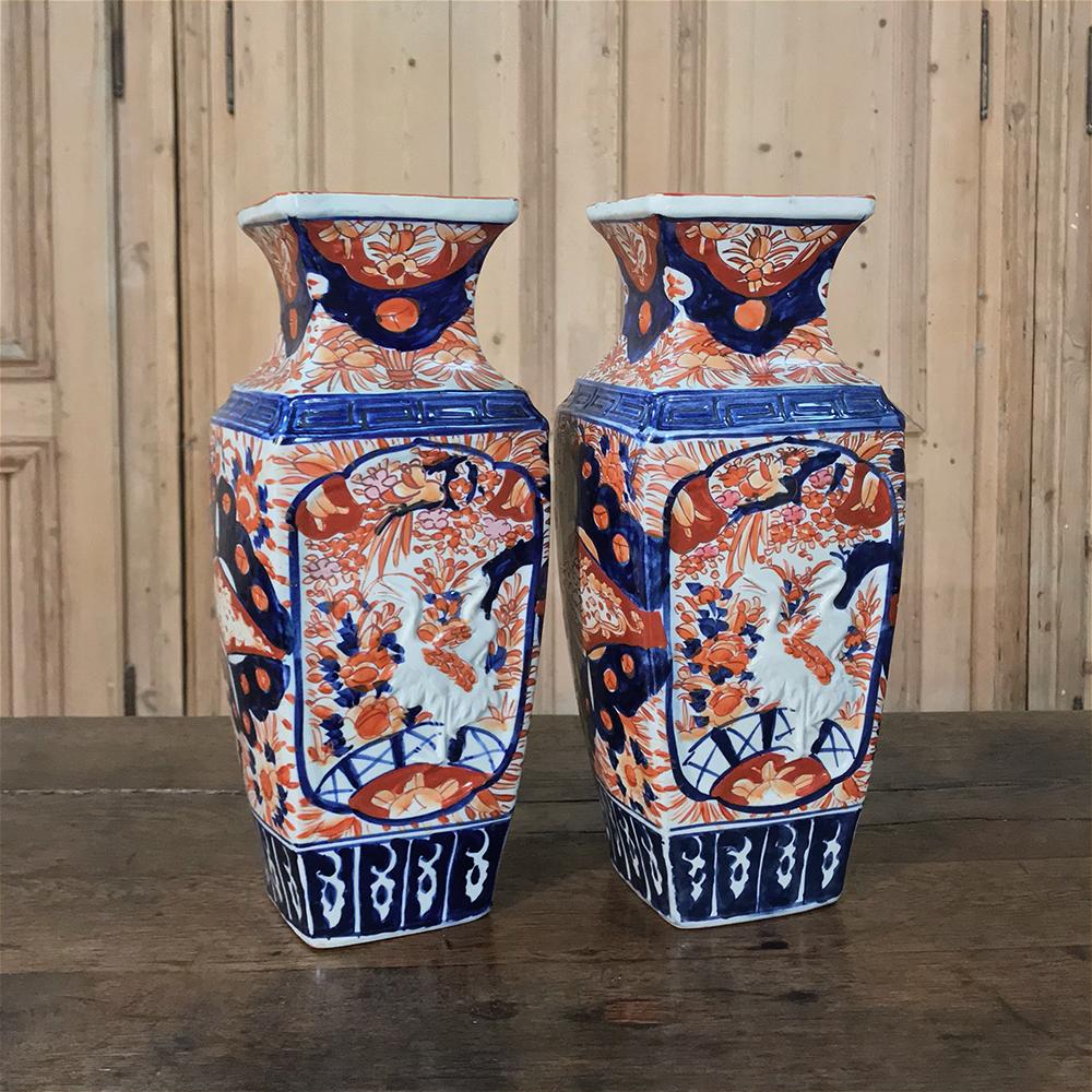 Pair of Meiji Period Japanese Imari porcelain vases (Meiji Period 1868-1912) feature an unusual contoured square shape, and are beautifully hand-painted all around for visual appeal from any angle! Molded with bird motifs, more specifically cranes,