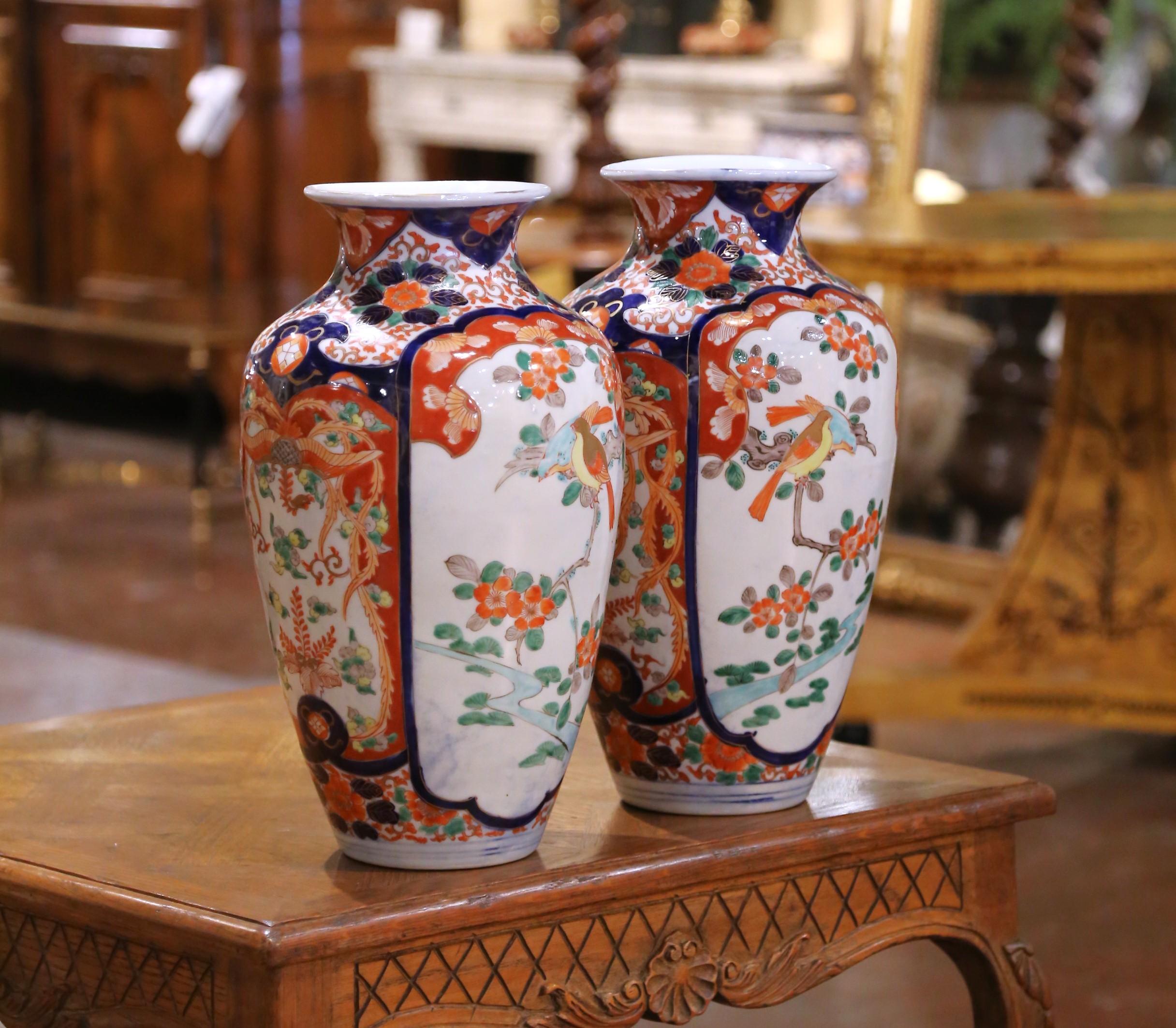 Una graziosa coppia di vasi giapponesi in porcellana Imari, realizzati durante il periodo Meiji (1868-1912). Ogni vaso colorato presenta un bordo svasato sopra un corpo a balaustro affusolato, meticolosamente dipinto a mano nella classica tavolozza