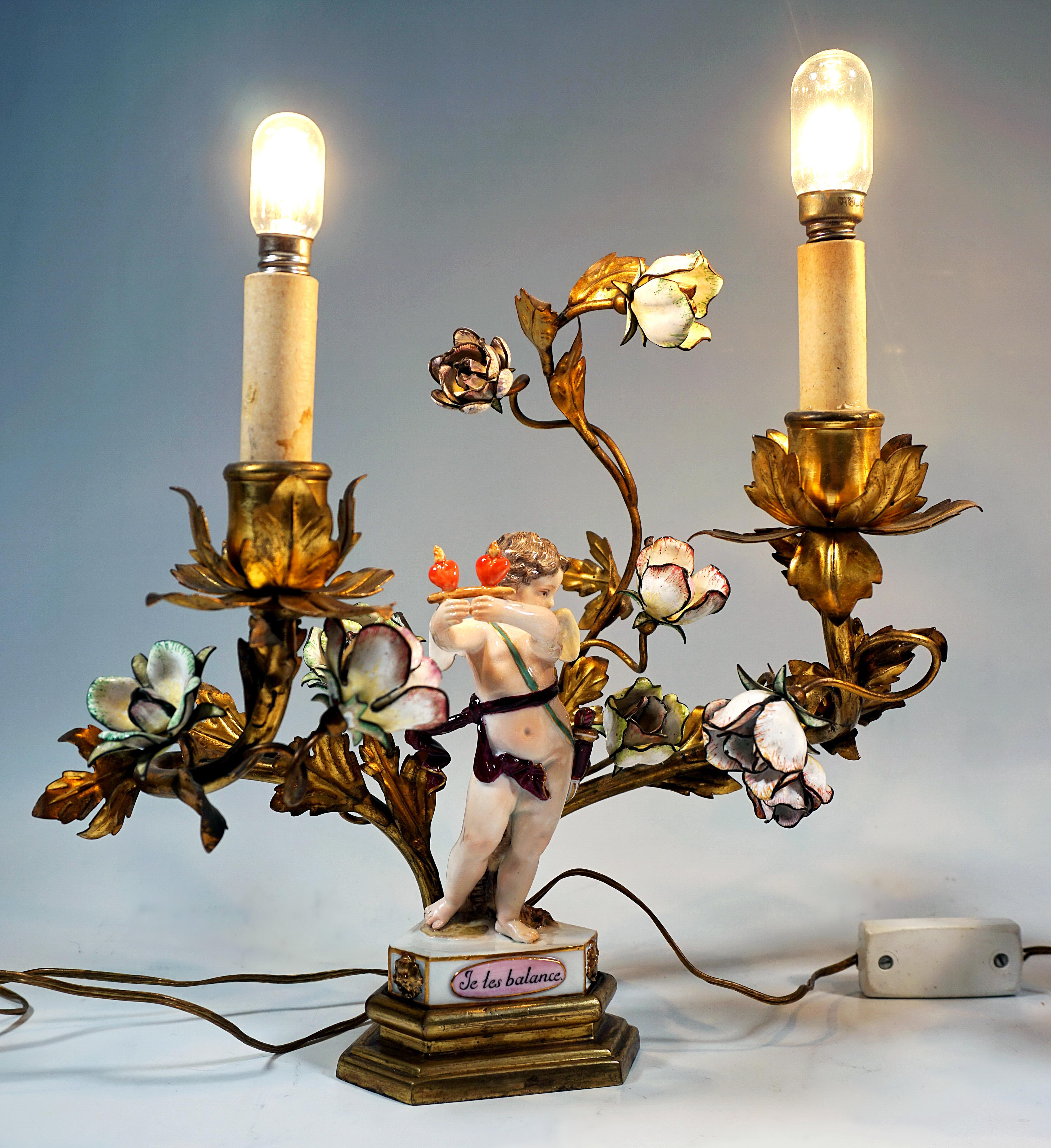Con figure in porcellana dell'epoca di origine, intorno al 1775:
Due lampade elettrificate in bronzo con doratura: un piedistallo profilato di forma triangolare con angoli smussati come piede e base per un putto di Meissen, sul retro due tubi di