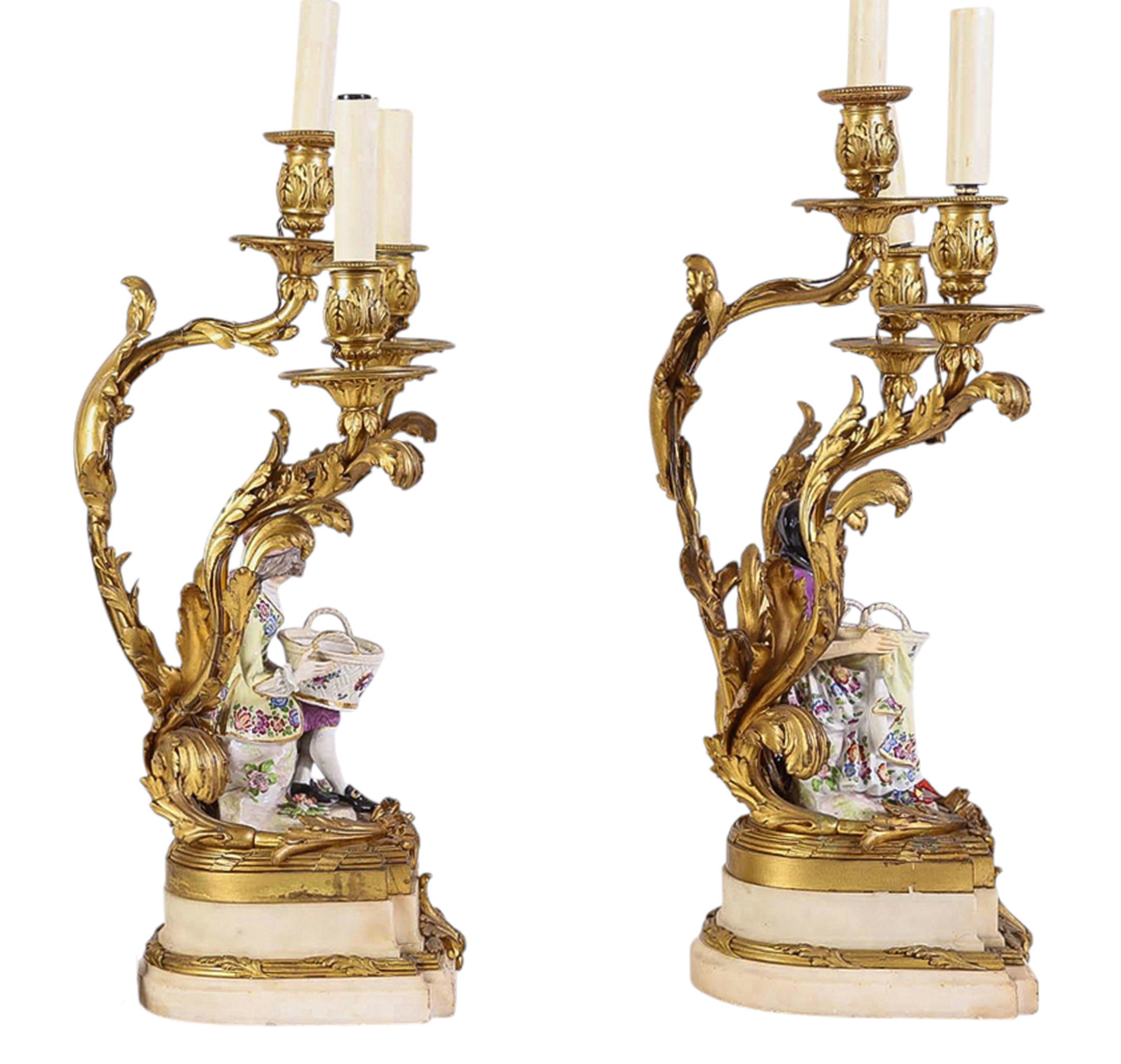 A pair of original Meissen figures circa 1765 modeled by J.J. Kändler. Depicting a young couple holding baskets with bright pastel glazes. Later mounted on cast in rococo style French marble and ormolu bases with acanthus leaf branches with