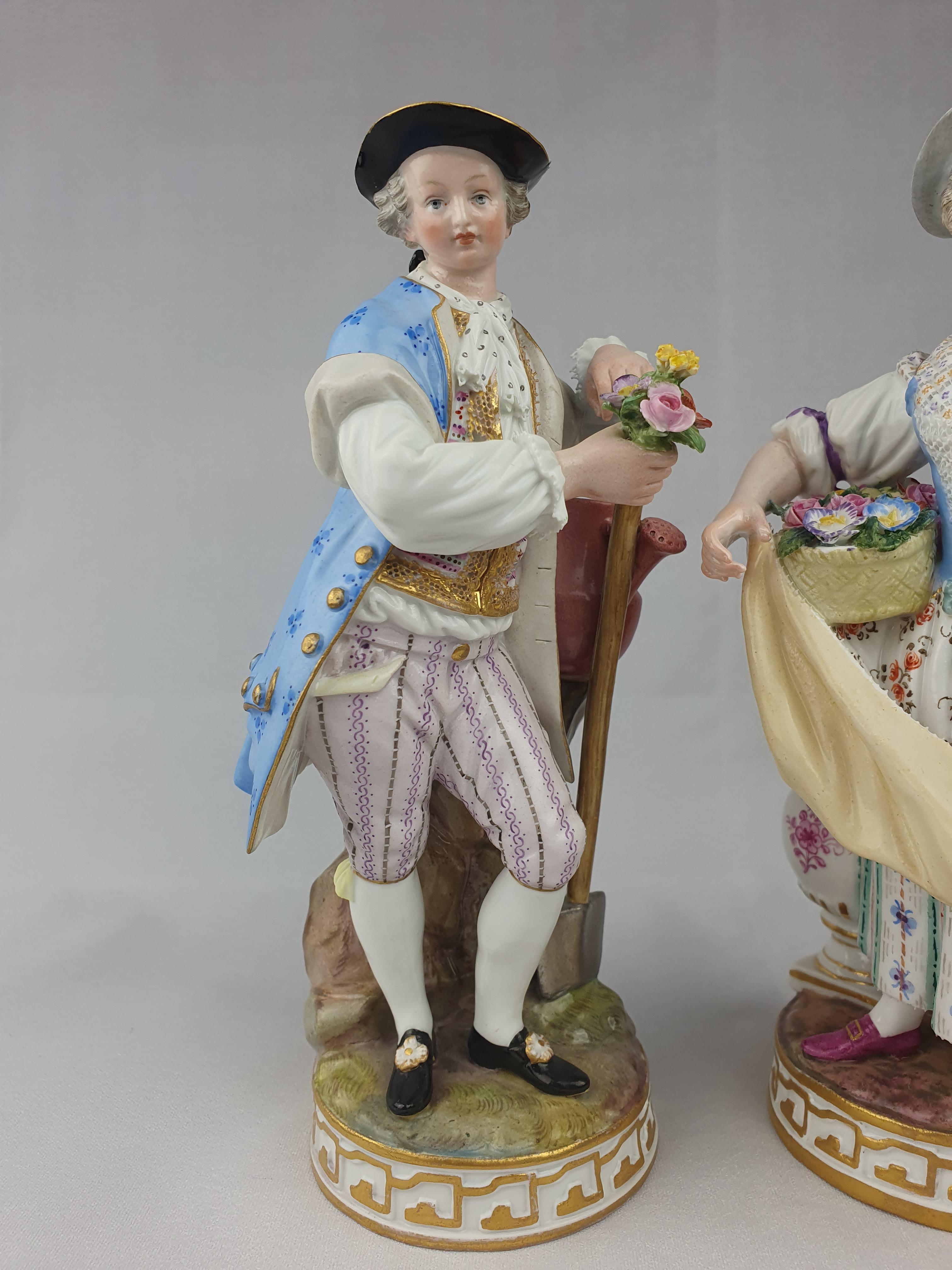 Pair of Meissen Gardeners. First modelled by Acier c.1777. The man leaning on his spade handle with watering can under his elbow. The woman with a basket of flowers held against her waist with her right hand. In her left hand she holds a pruning