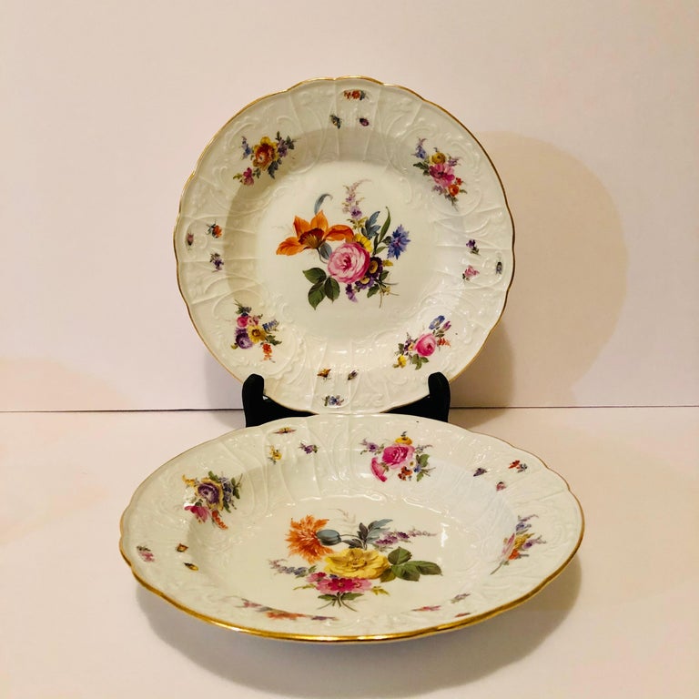 I want to offer you this wonderful pair of Meissen soup bowls beautifully painted with different flower bouquets and insects. Like on the historic Meissen swan service, these bowls also have elaborate raised white porcelain decorations of flowers