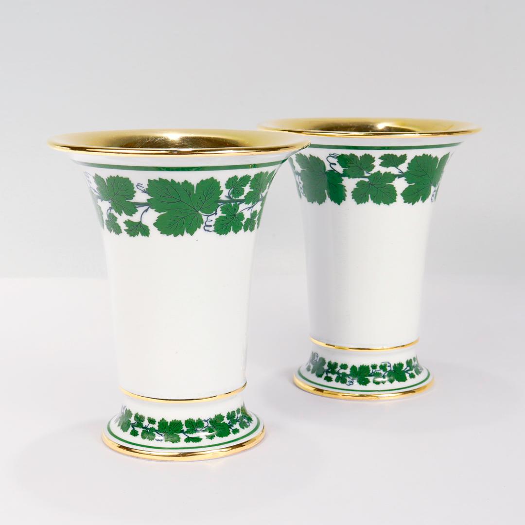 A fine pair of antique porcelain flower vases.

By the Meissen Porcelain Manufactory.

In the Ivy or Grapeleaf pattern.

With bands of green vines around the circumference and the top end of the foot, further highlighted with gilt bands.

Fully