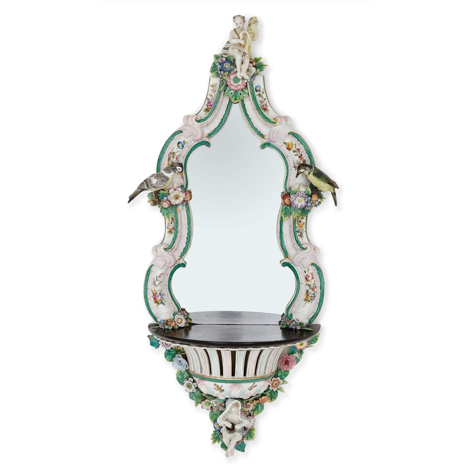 Pair of Meissen style porcelain and ebonised wood mirrored wall brackets
German, late 19th Century 
Height 88cm, width 36/40cm, depth 19cm

This superb pair of wall brackets are a masterclass in the Meissen design style. 

The mirror of each bracket