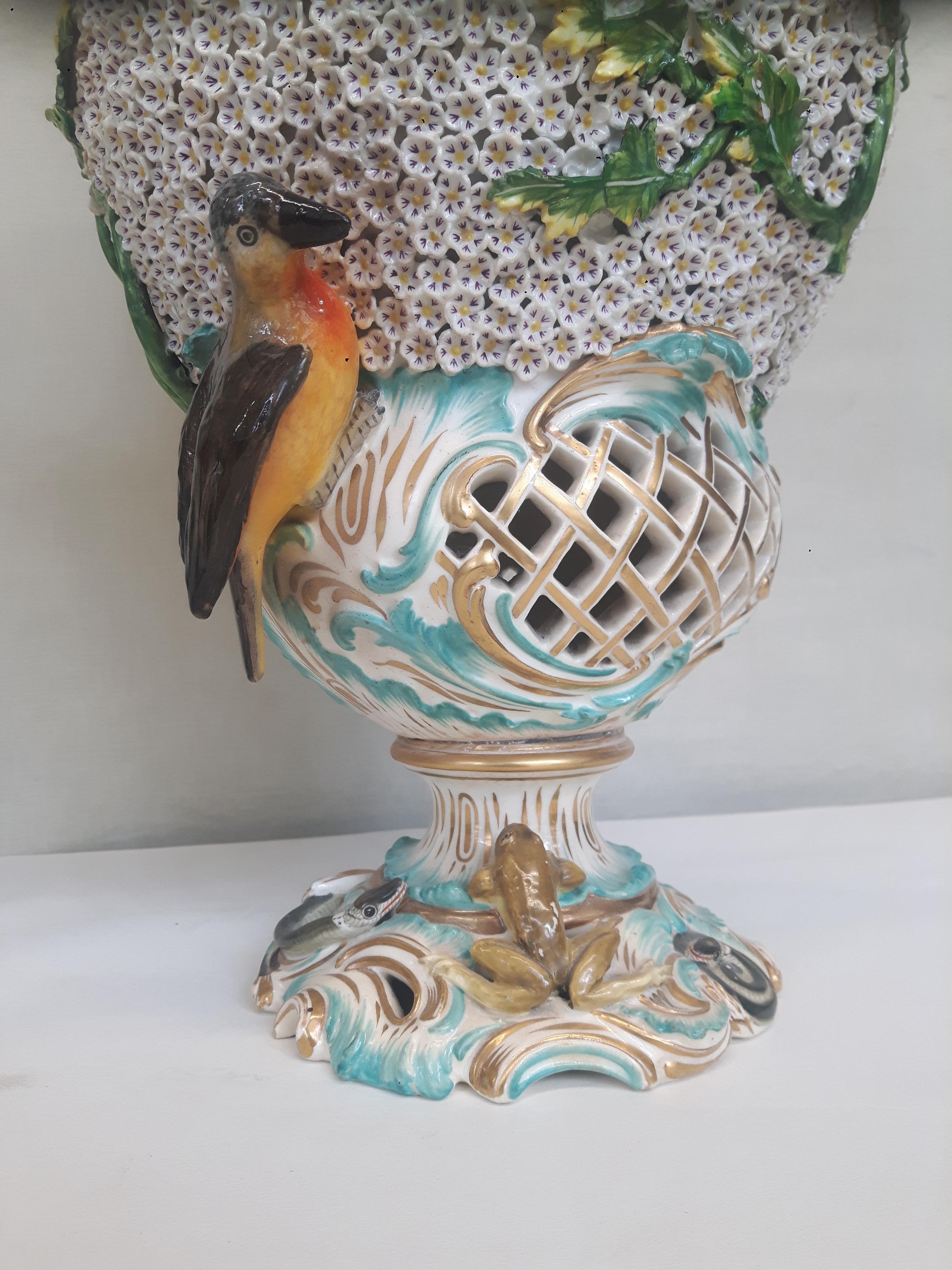 A pair of Meissen style 'Schneeballers' vase, applied with branches and birds abpve pierced vases. Covers surmounted with bouquets of flowers and birds.