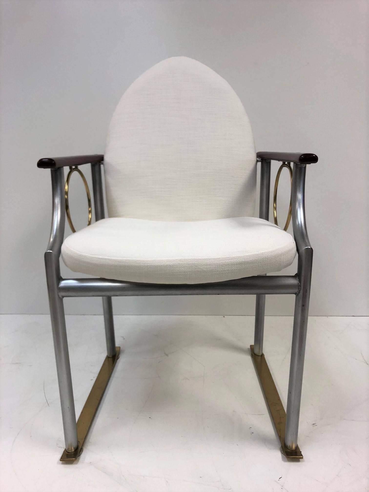 Pair of Memphis style armchairs. Chairs are newly upholstered in linen. Has mahogany arms, a painted steel frame with circular bronze trim and bronze base.