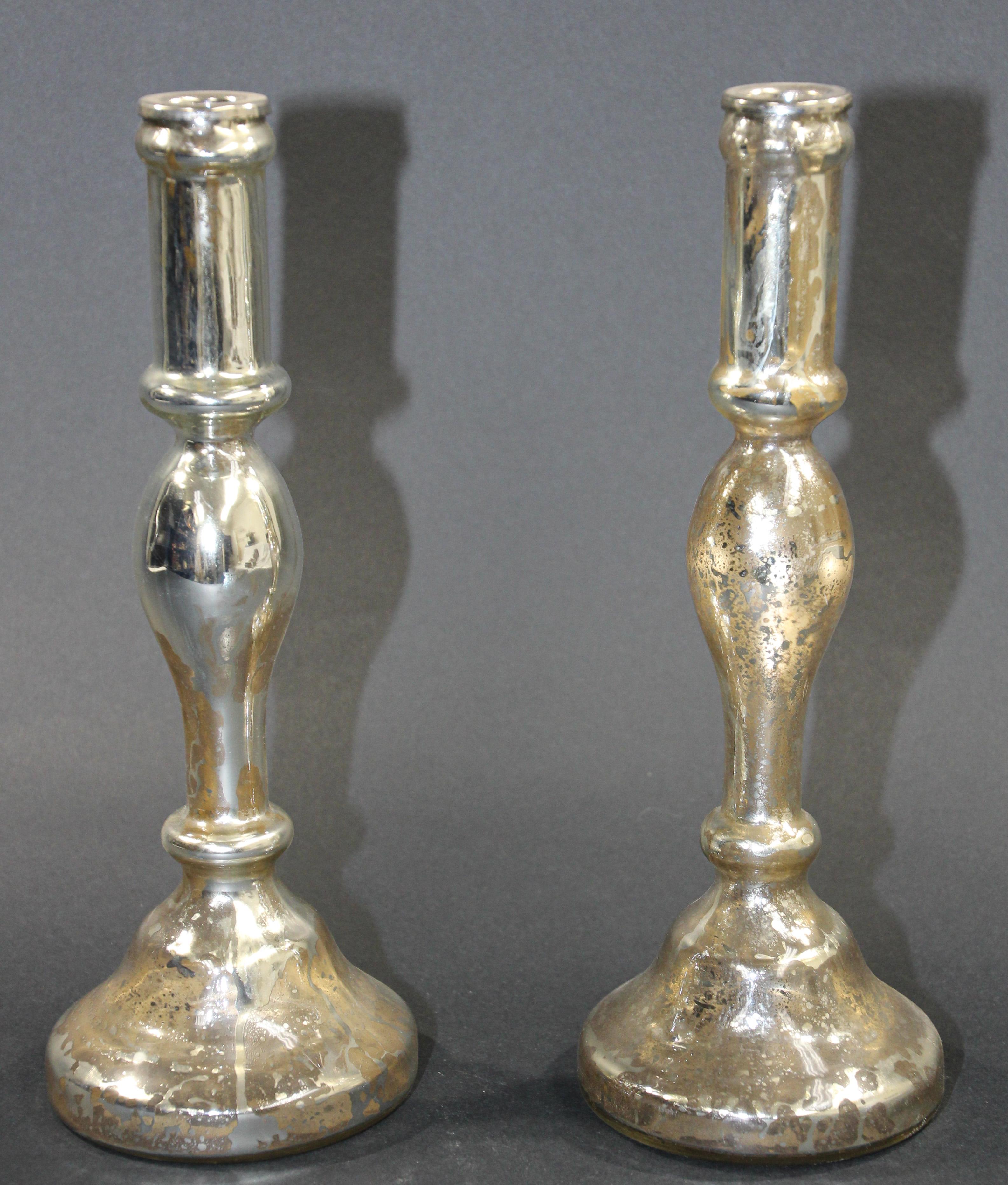 Pair of mercury glass silvered candlesticks.
Silvered mercury glass is mouth-blown double walled, then silvered between the layers with a liquid silvering solution. The silvering is a heated solution of silver nitrate and grape sugar. The rough