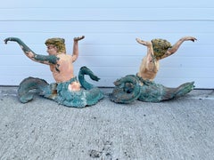Coppia di supporti scultorei per tavolo a forma di tritoni, in bronzo fuso