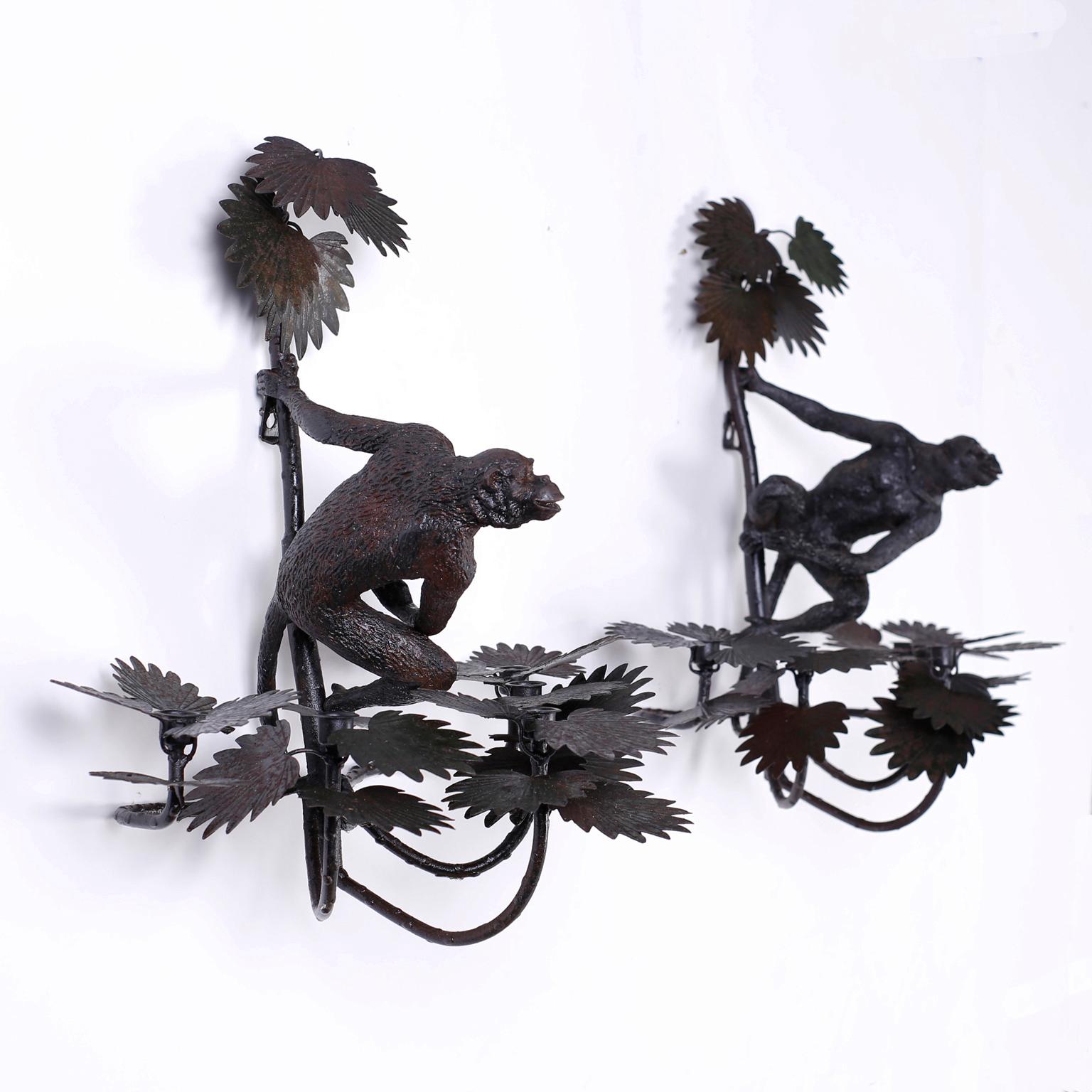 Pair of wall sconces with a slightly oxidized finish, five candle cups in palm leaf clusters, and featuring cast iron monkeys in a familiar, taunting pose.