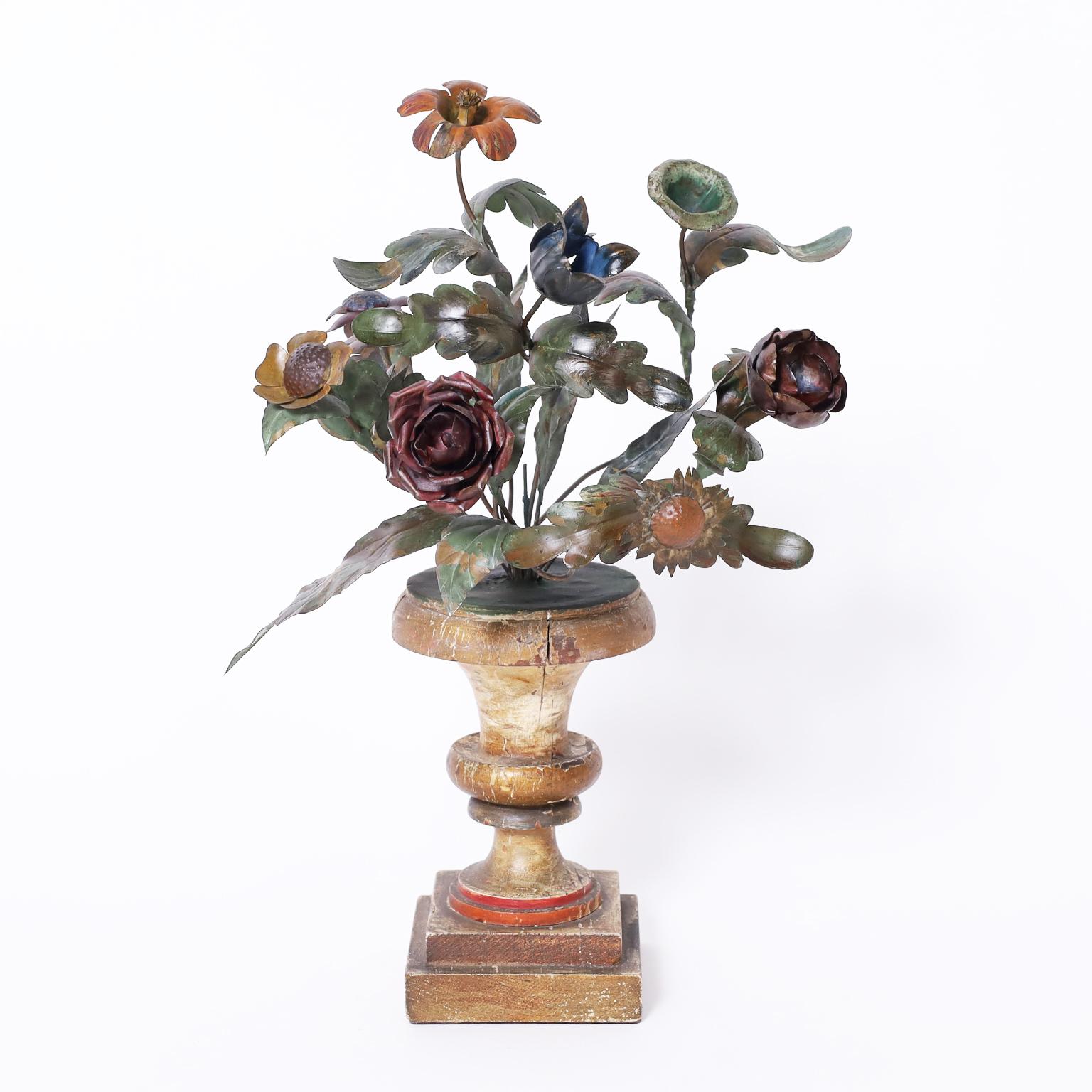 Pair of antique Italian garnitures with floral tole bouquets in classical wood urns retaining their original paint.