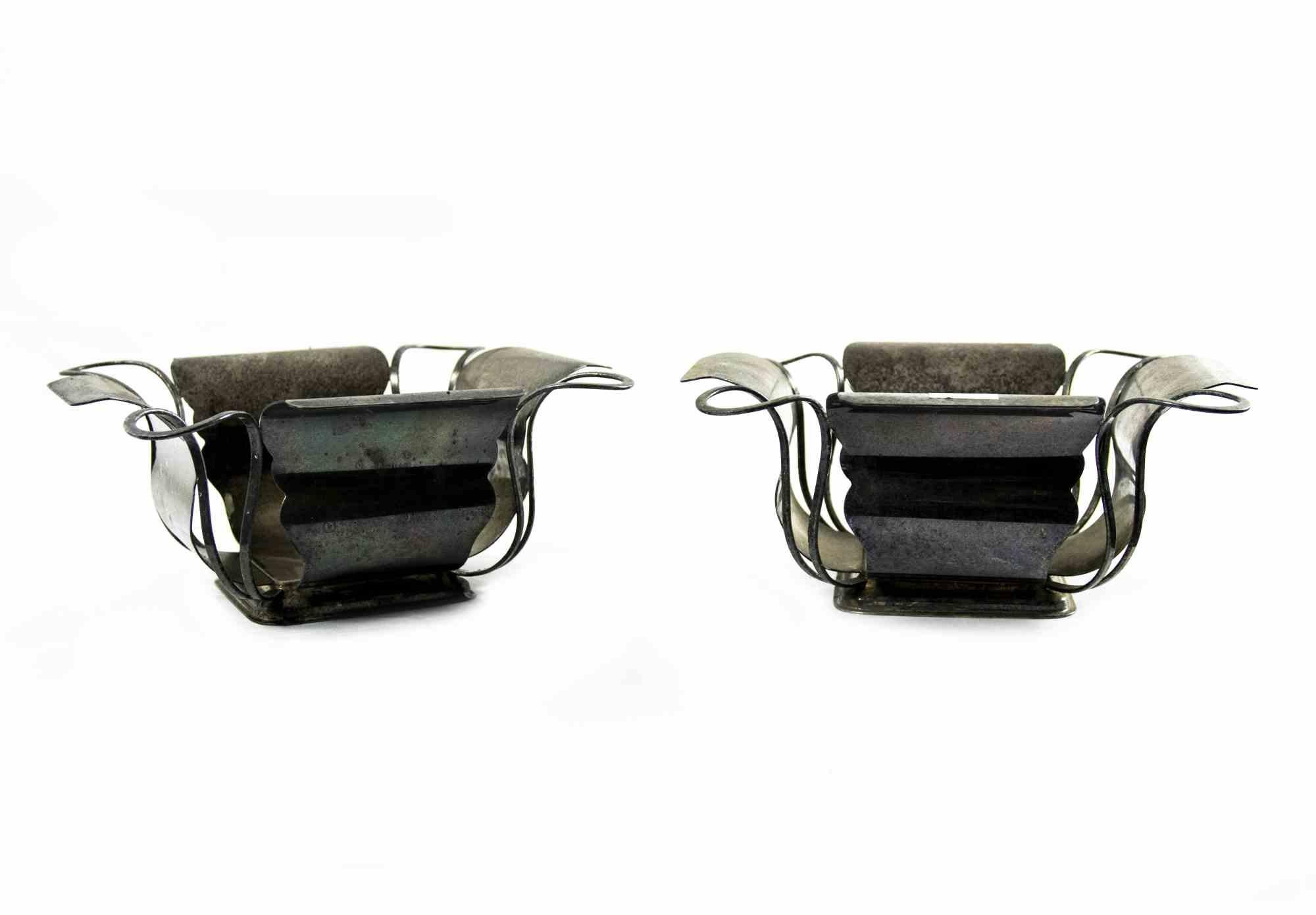 Ein Paar Metall-Mittelstücke ist ein Original-Deko-Objekt, das in der Mitte des 20. Jahrhunderts hergestellt wurde.

Hergestellt in Italien.

Die Tafelaufsätze sind in gutem Zustand. Auf der Oberfläche sind verschmutzte Flecken vorhanden.