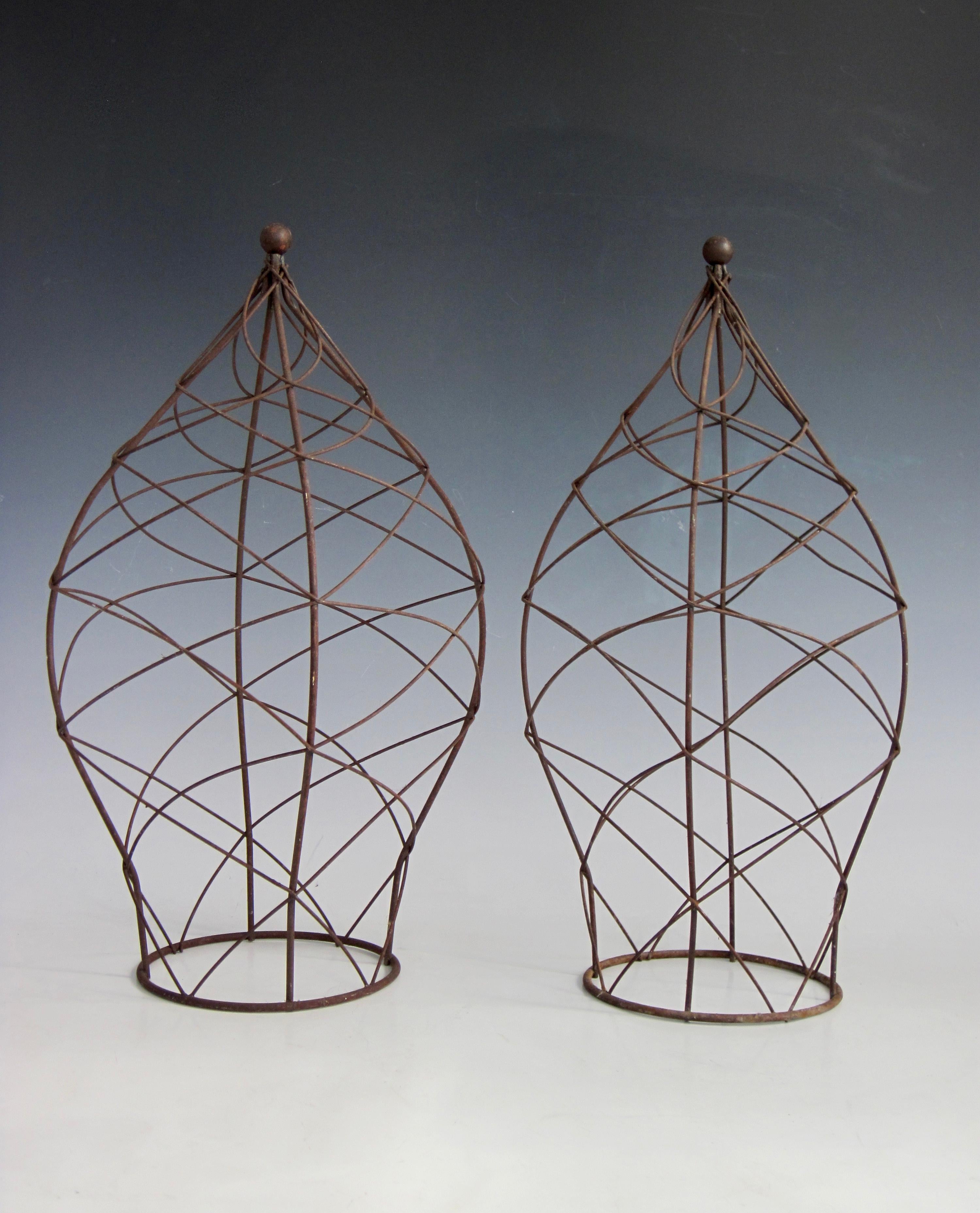 Pair of metal garden topiaries with spiraling trails on an hourglass type shape leading to a peak with a round ball finial. Nicely patina'd and structurally sound.
One measures 18.25