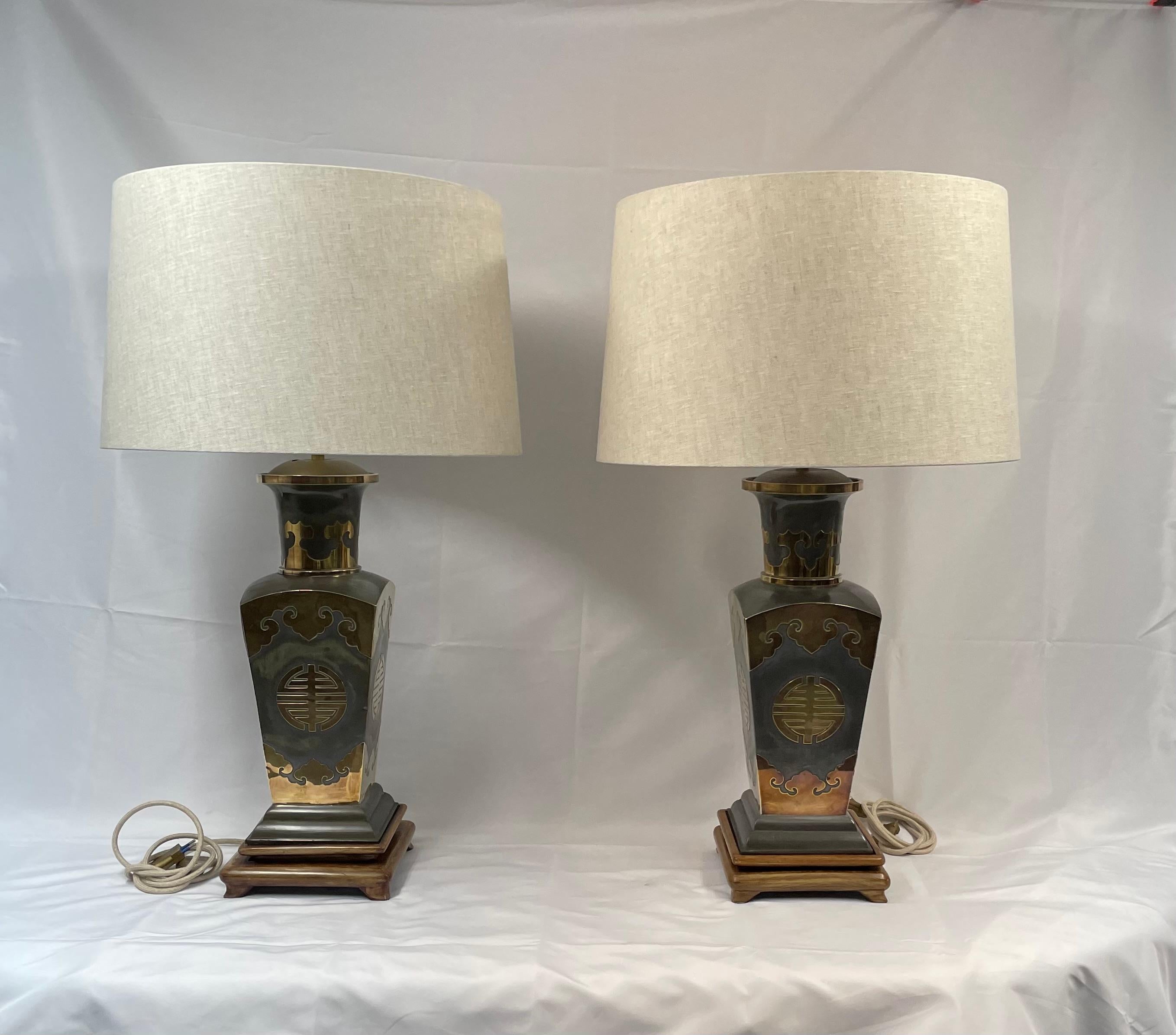 Pair of metal lamps with brass applications on wooden bases. 
70s.