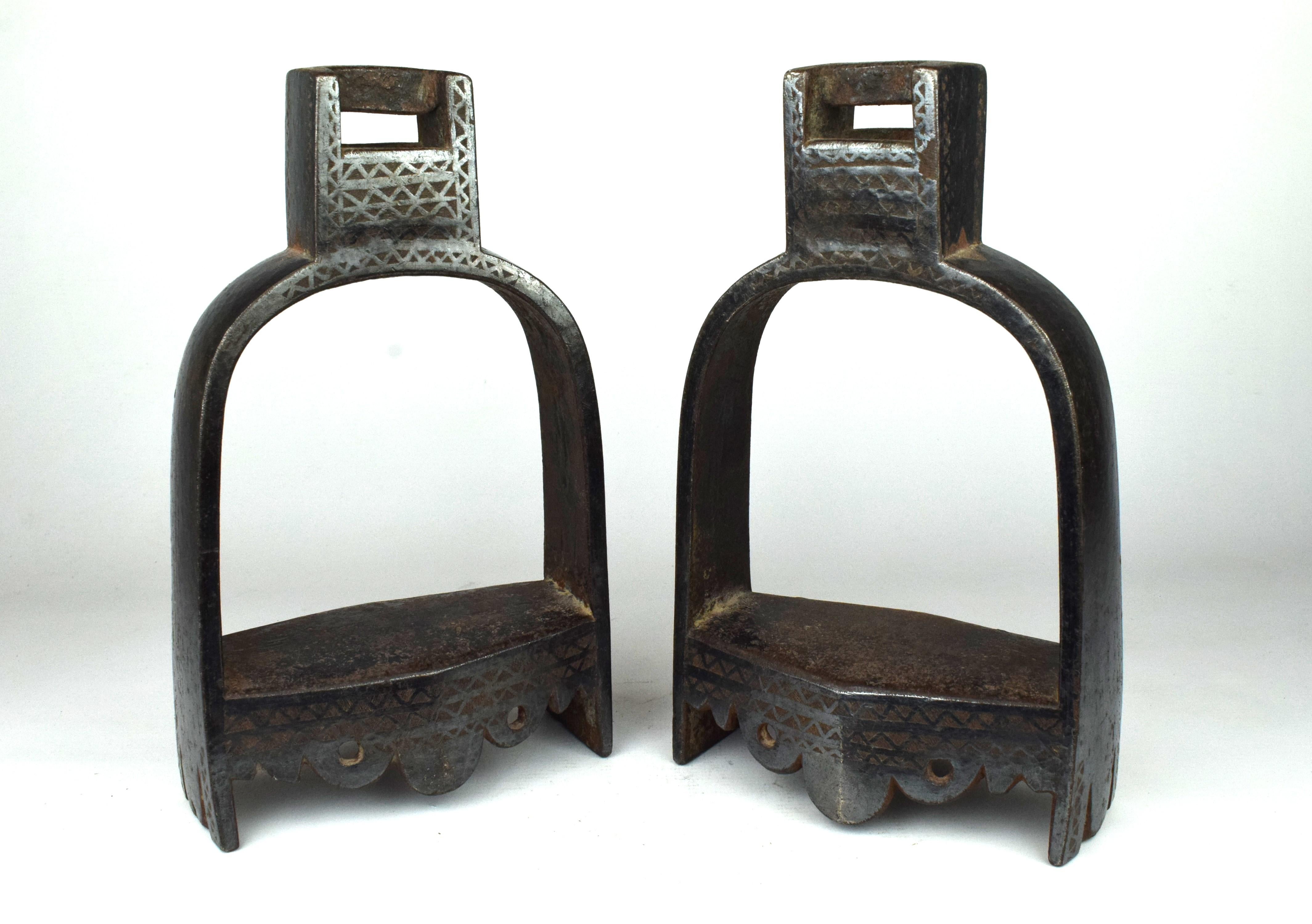 Das Paar Mogul-Pferdebügel aus Metall mit Silbereinlage aus dem 19. Jahrhundert ist ein eindrucksvolles Beispiel für die Reitausrüstung, das die Kunstfertigkeit und das handwerkliche Können der Mogulzeit widerspiegelt.

Die Steigbügel sind aus einem
