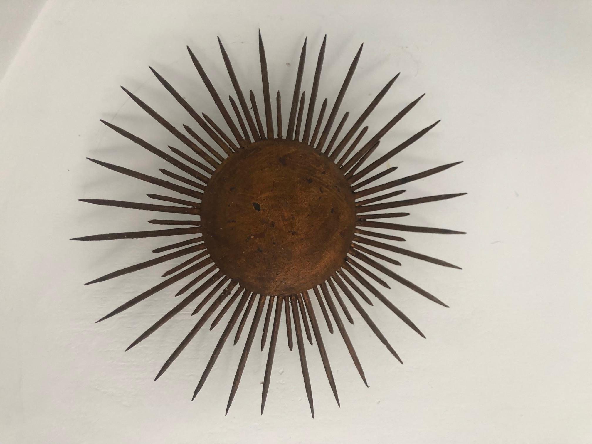 Pair of fully functional repurposed metal sunburst wall sconces with faded gilt finish. Have an industrial feel but elegant at the same time. Striking and unusual and very impactful effect when lighting.