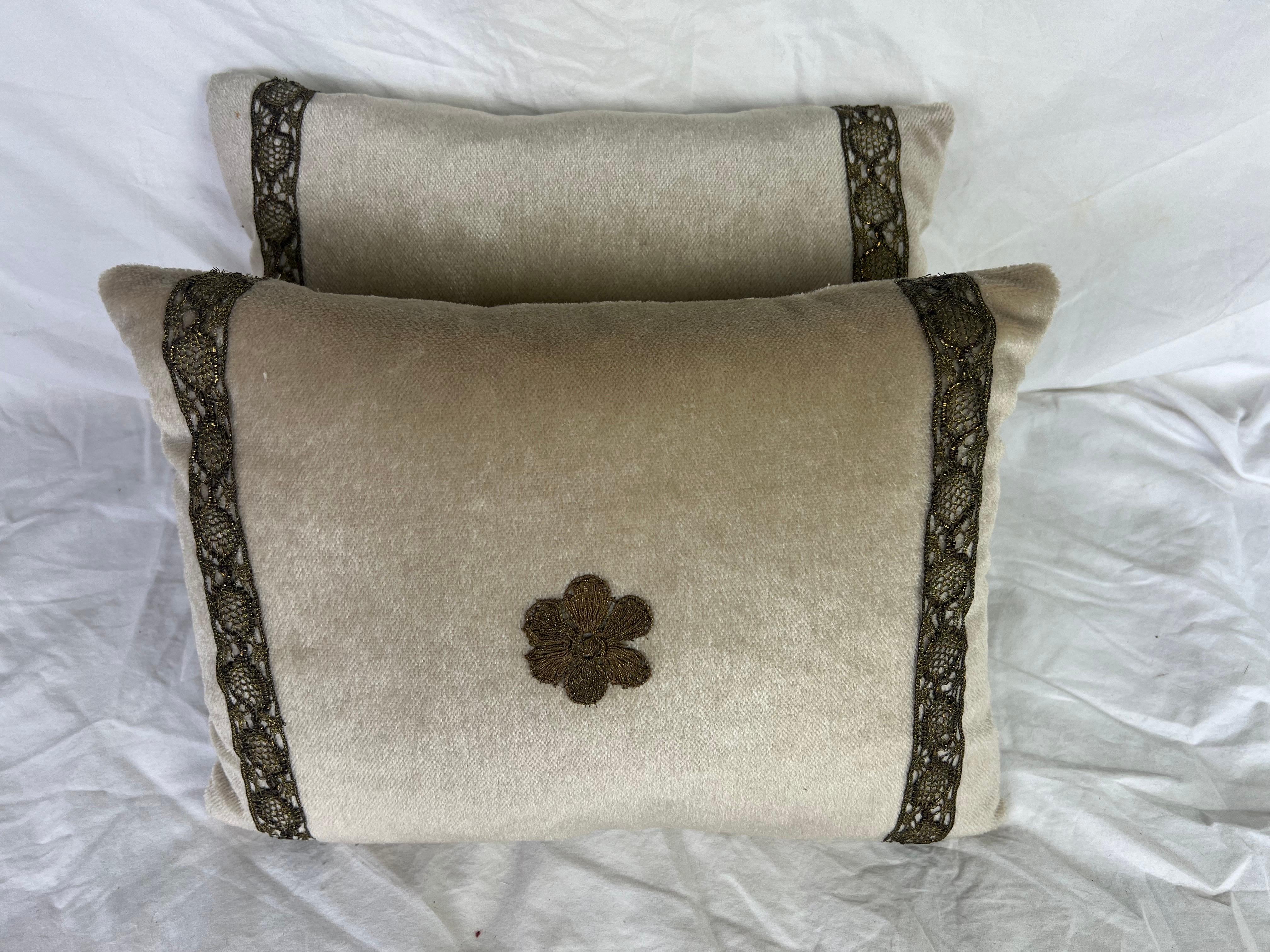 Coppia di cuscini personalizzati con applicazioni metalliche di Melissa Levinson.  Questi cuscini decorativi hanno il fronte in velluto neutro e il retro dorato.  Ogni cuscino è impreziosito da un piccolo ricamo floreale centrale in metallo, che