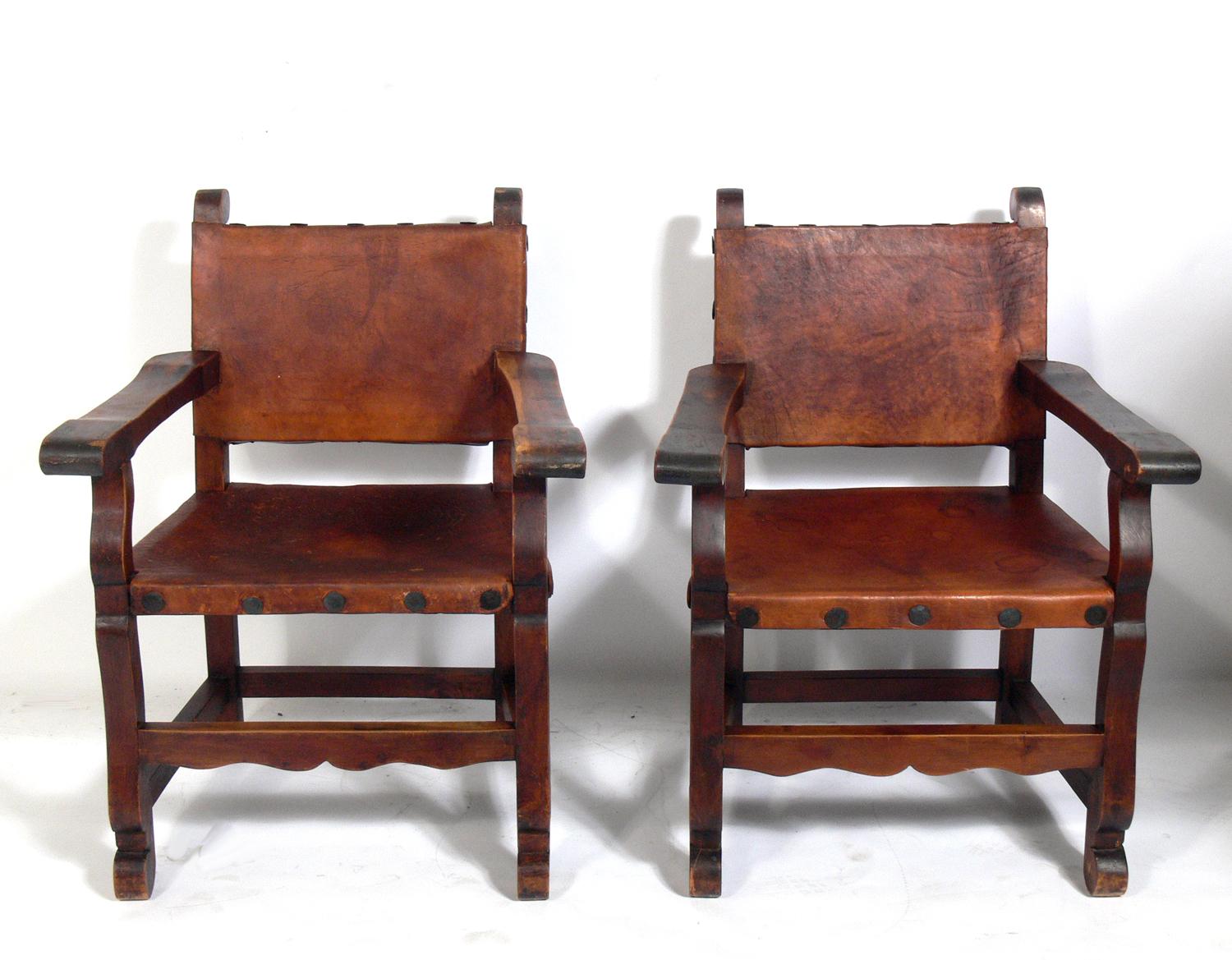 Pair of Mexican leather arm chairs, Mexico, circa 1950s. They retain their original distressed patina. They would be perfect in a California or Mexican hacienda or anywhere you want the organic rustic vibe of aged leather and wood.