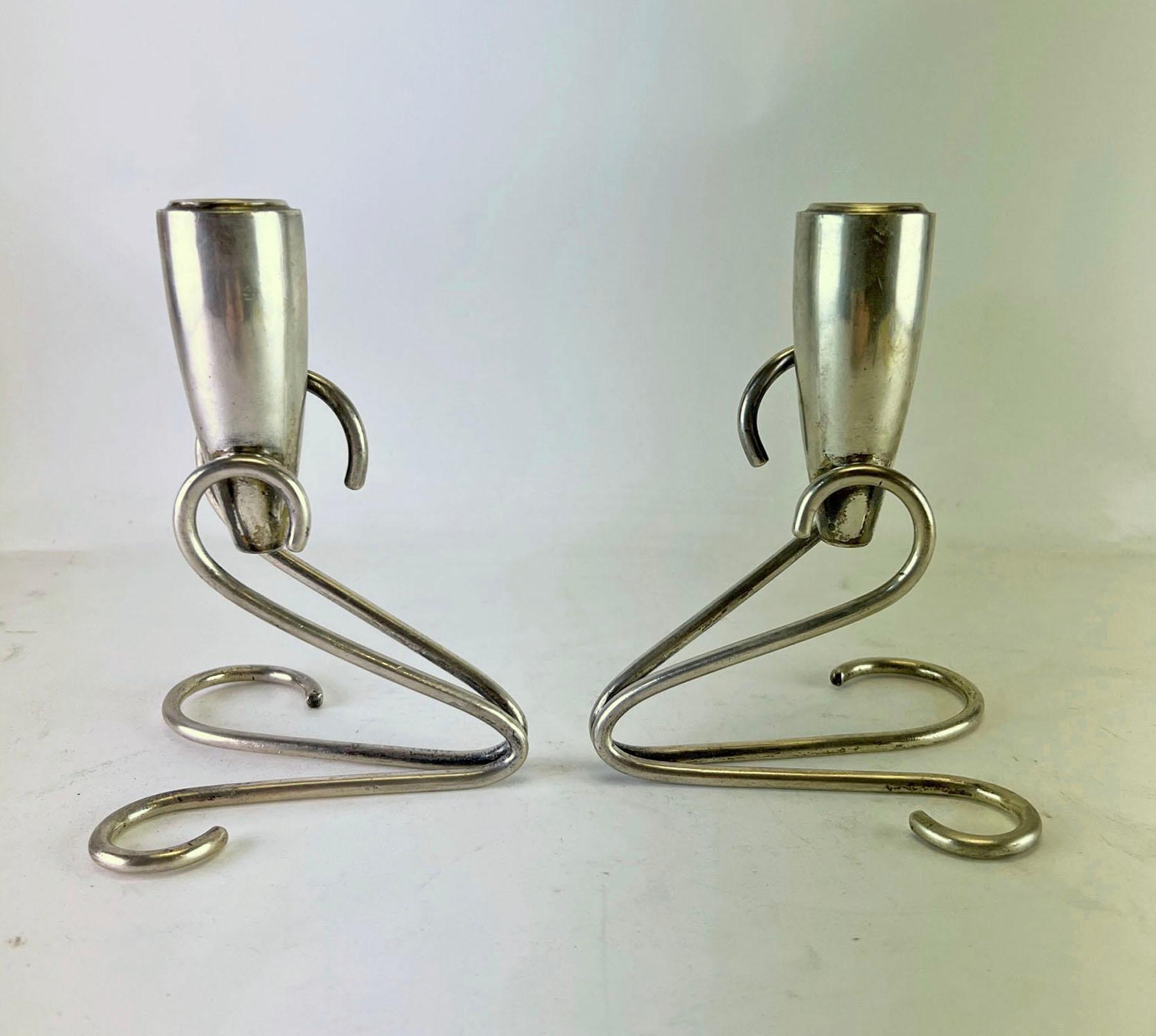 Pair of sterling silver candlesticks in the style of Georg Jensen, circa 1960s. Both marked sterling 925, and with a maker's taller mark unknown to us, but definitely of Mexican origin.