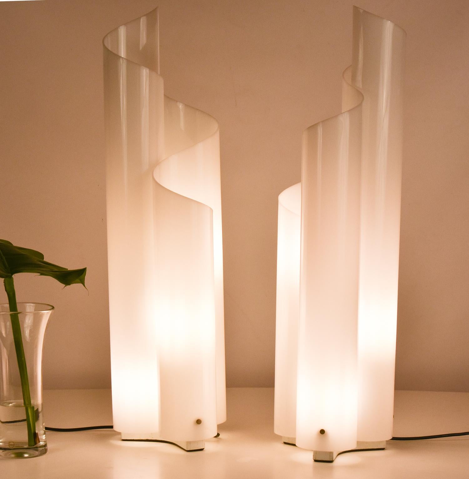 La lampe de table Mezzachimera a été conçue par Vico Magistretti pour Artemide en 1969.
La base est en métal peint en blanc et la structure/diffuseur en méthacrylate opale blanc incurvé à chaud.
Ces magnifiques lampes sont anciennes et en très bon