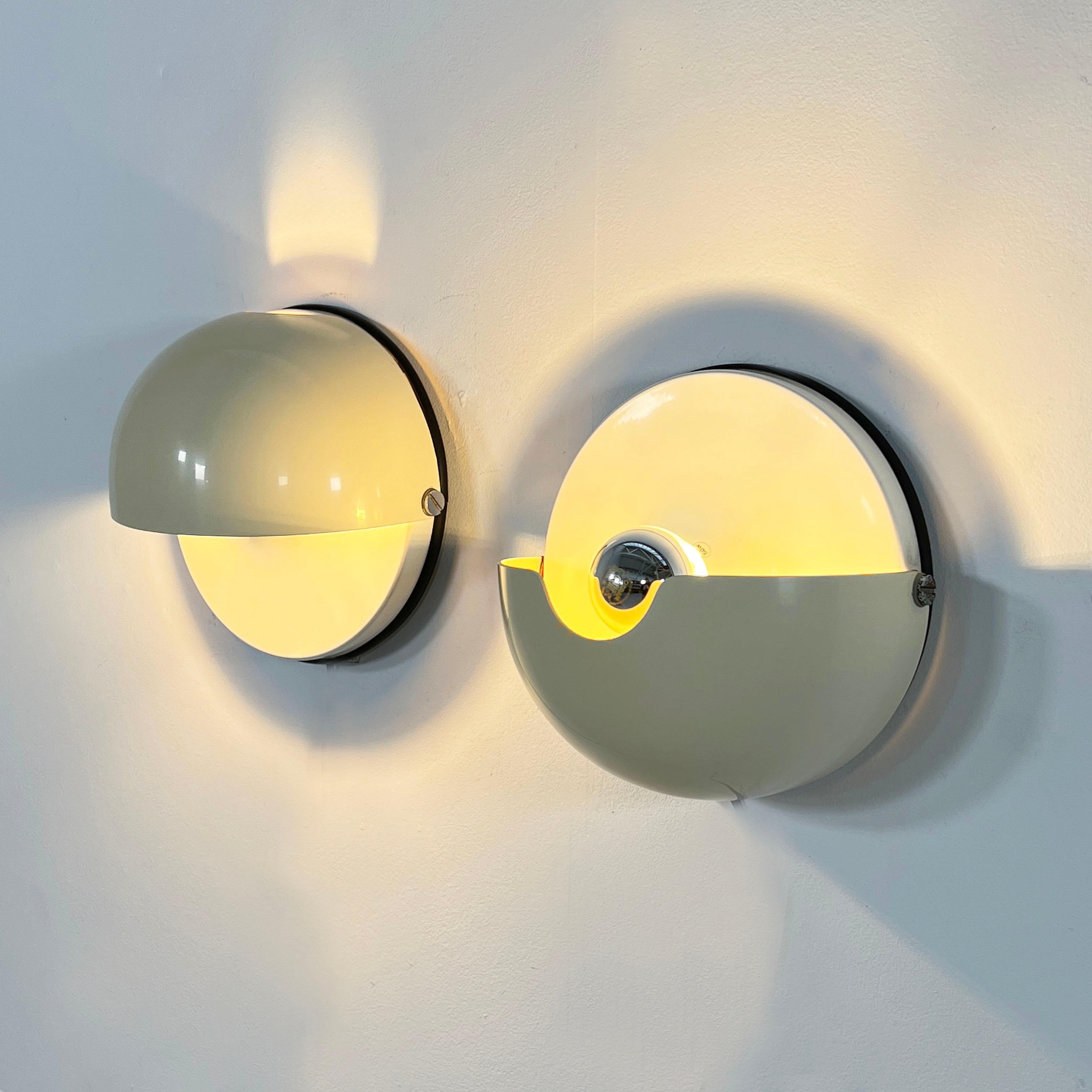 Pair of Mezzanotte Wall Lights from Guzzini, 1970s
Producer - Guzzini
Model - Mezzanotte Wall Lamp
Design Period - Seventies
Measurements - Width 24 cm x Depth 14 cm x Height 24 cm 
Materials - Metal, Plastic
Color - White, Beige
Electrical