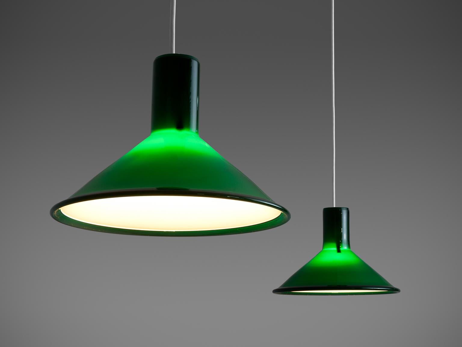 Michael Bang for Holmegaard pair of glass pendant lights, in green glass, Denmark, 1970s. 

These small green glass pendants designed by Michael Bang for Holmegaard are in green glass and the inside has a white inner casing. These pendants have an