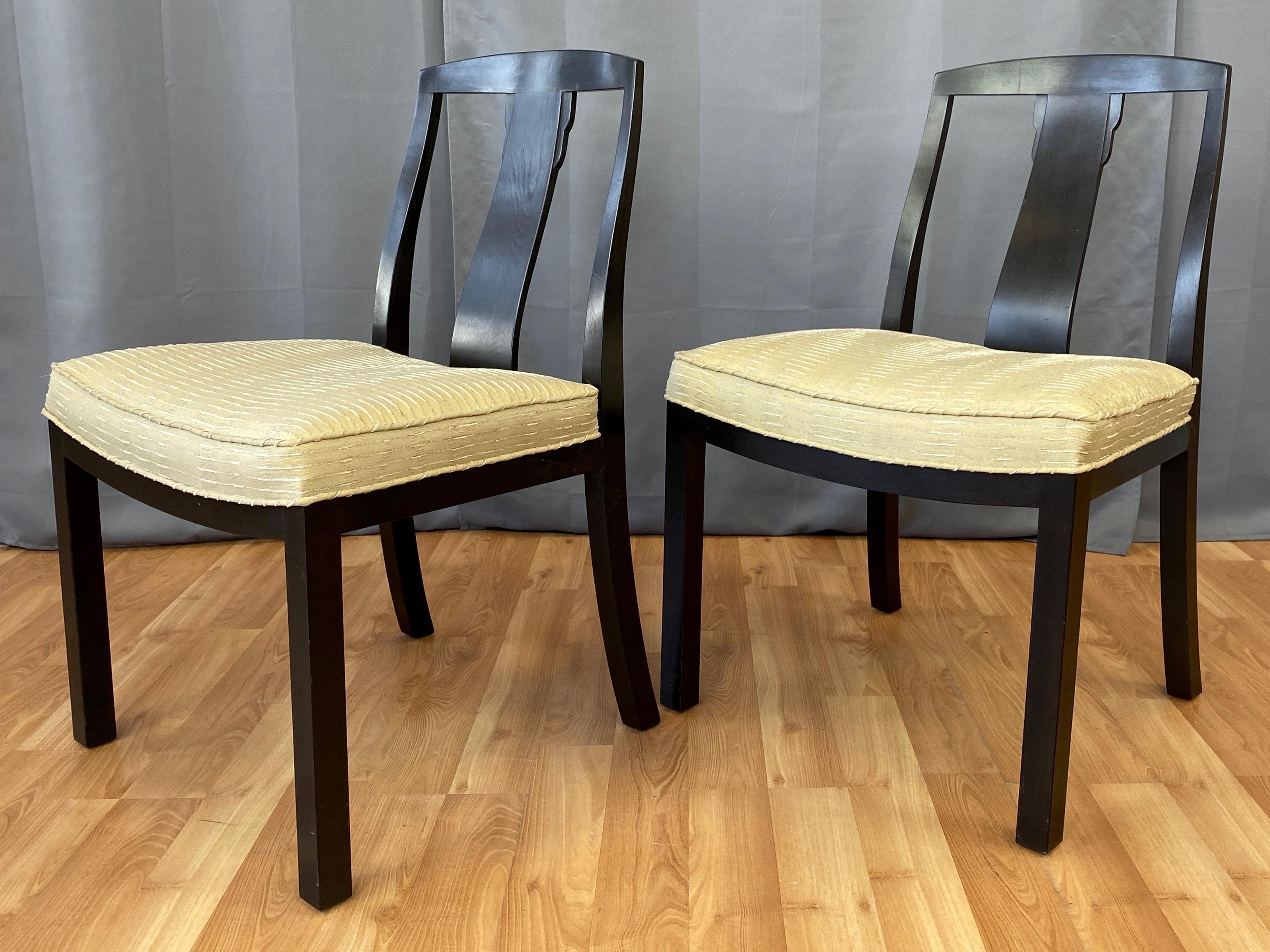 A pair of 1950s Hollywood Regency dining or side chairs by Michael Taylor for Baker Furniture.

Very handsome design distinguished by clean lines and a elegantly curved T-shaped back with subtle detailing. Original ebonized finish walnut with rich