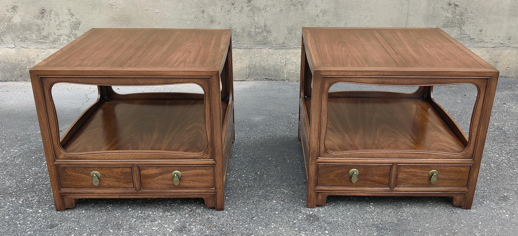 This pair of large end tables or nightstands were designed by Michael Taylor for Baker's Far East Collection. Featuring a rich mahogany construction, its finish is dramatic and elegant. There are two drawers on the bottom of each that have clean