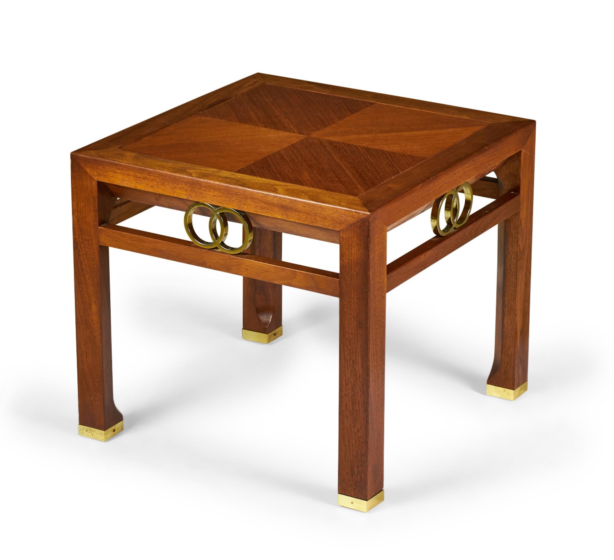 Pair of American mid-century square walnut end table with a four-square veneer top and interlocking brass ring detail between the tabletop and a support rail, resting on four square walnut legs ending in brass sabots. (Michael Taylor for Baker
