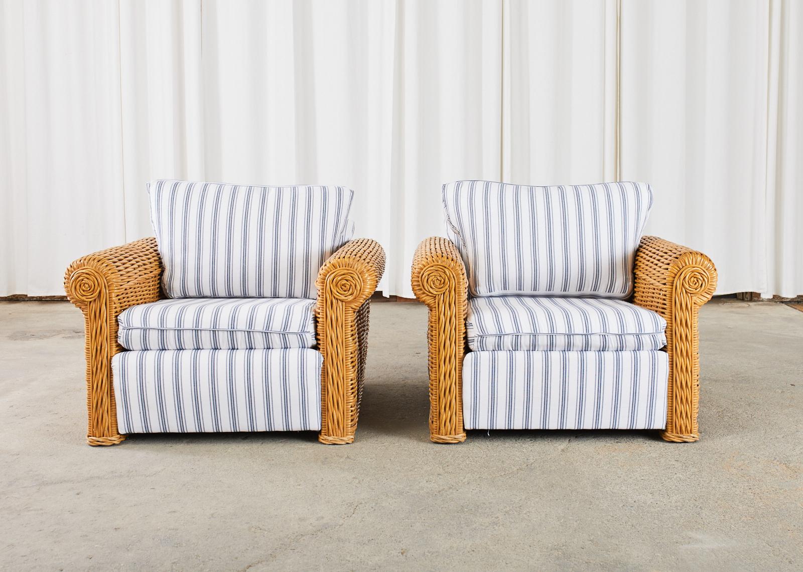 Fantastic pair of large club chairs or lounge chairs made in the manner and style of Michael Taylor by Henry Link Designs. The chairs feature a wooden frame covered with woven rattan in geometric patterns and braided ends. The chairs represent