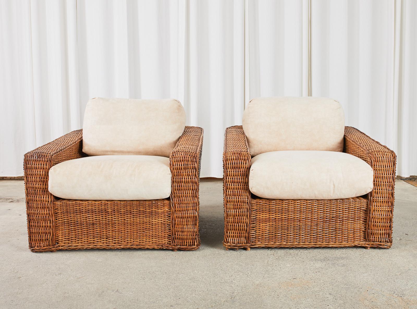 Grand pair of oversized woven rattan wicker cube shaped lounge chairs or club chairs made in the fabulous organic modern manner and style of Michael Taylor. The chairs feature a large bamboo and wood frame covered with woven rattan wicker with