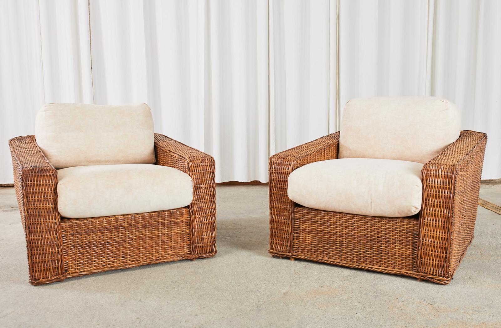 Grand pair of oversized woven rattan wicker cube shaped lounge chairs or club chairs made in the fabulous organic modern manner and style of Michael Taylor. The chairs feature a large bamboo and wood frame covered with woven rattan wicker with