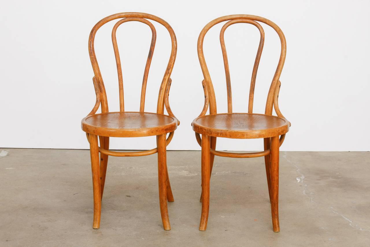 Iconic original pair of Michael Thonet's design number 18 bentwood Viennese cafe chairs. Produced at the factory in Czechoslovakia. This chair was formed from his quintessential bentwood design using one piece of wood to make the backrest and legs.