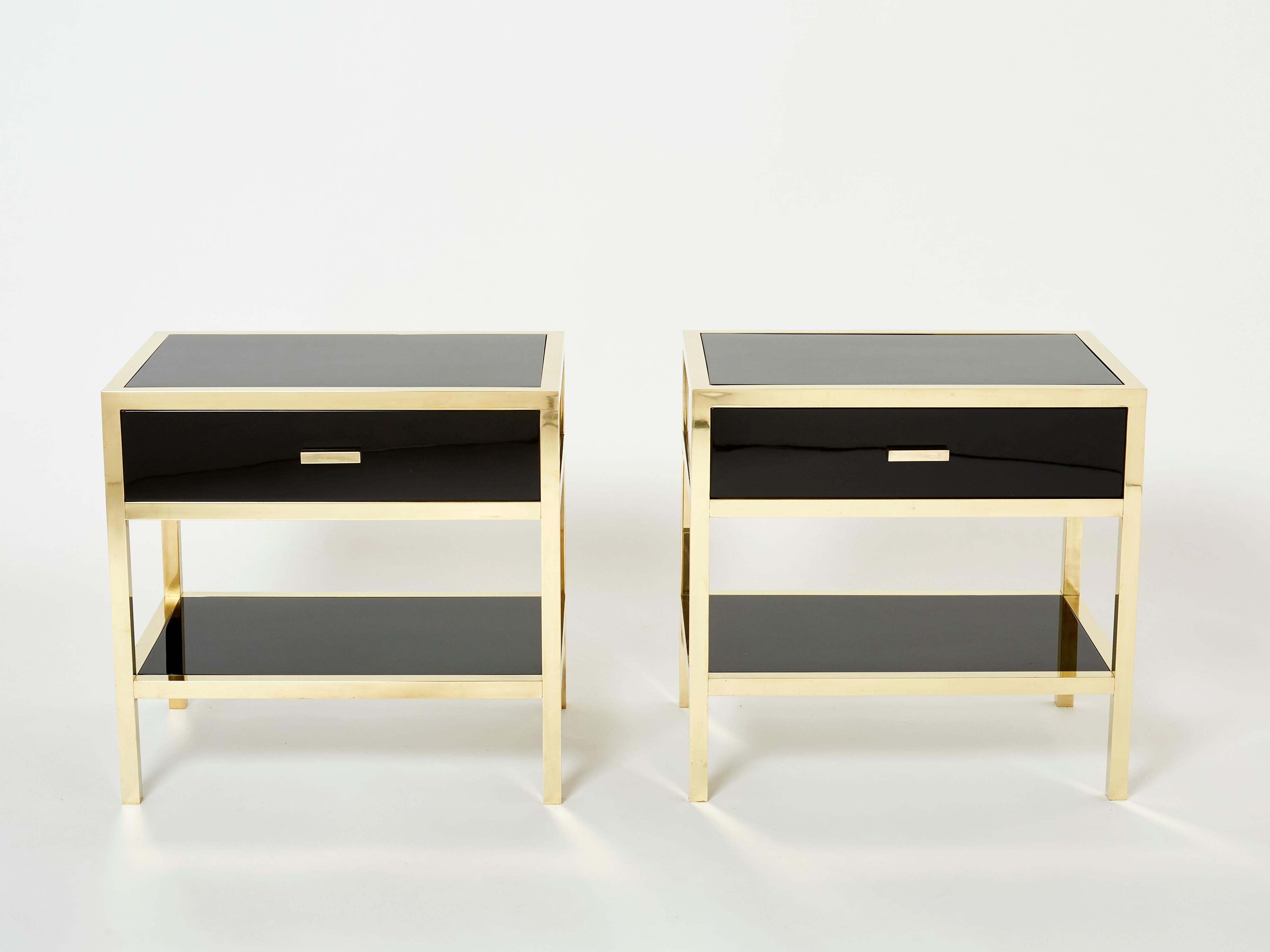 This rare pair of French midcentury single drawer black lacquered nightstands or end tables would be stunning in any room. Designed by Michel Pignères in France in the late 1970s, the shiny black lacquer paired with polished brass structure and