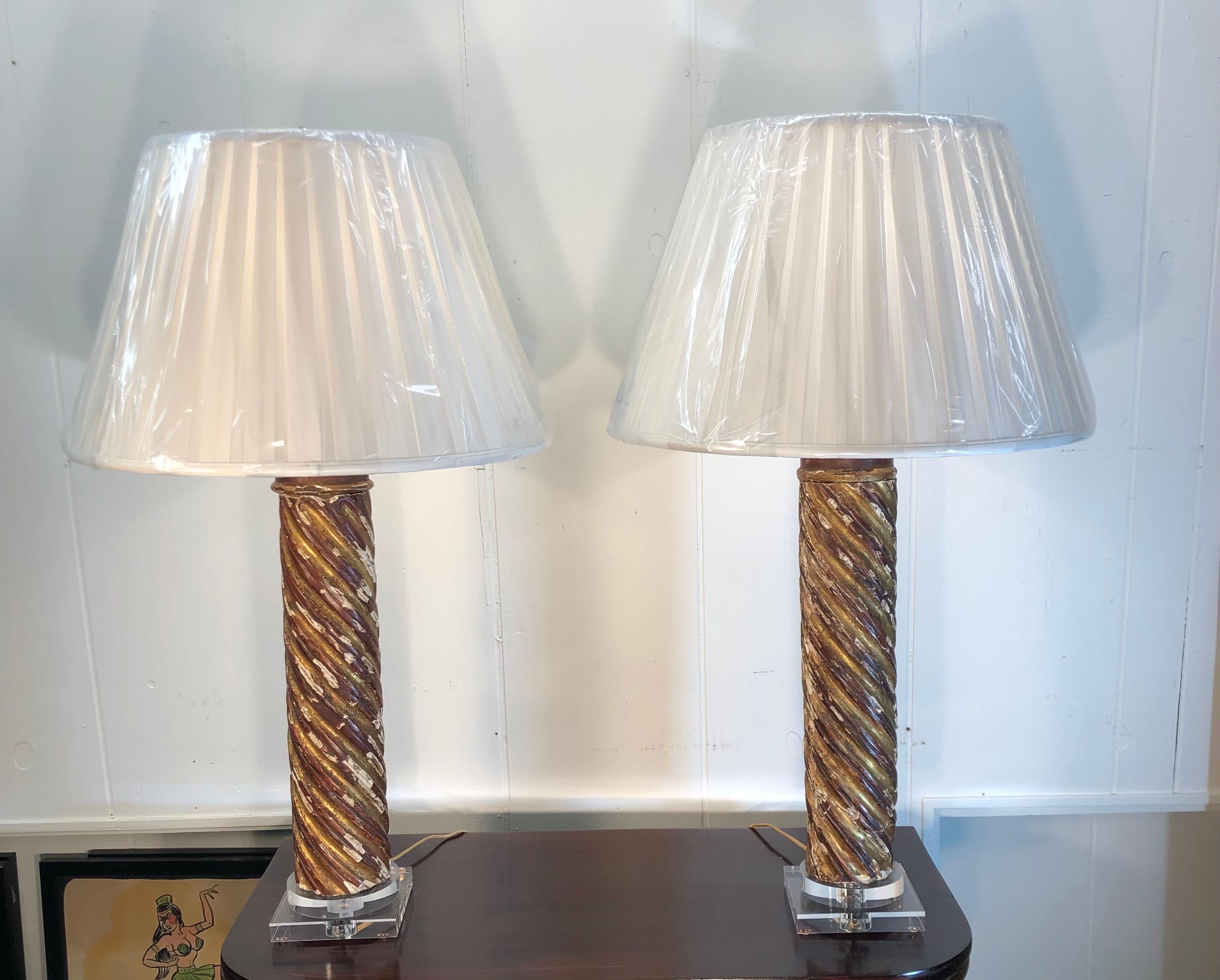 Pair of mid-18th century Italian giltwood column lamps on lucite bases. There are a total of four lamps available to be sold in pairs.