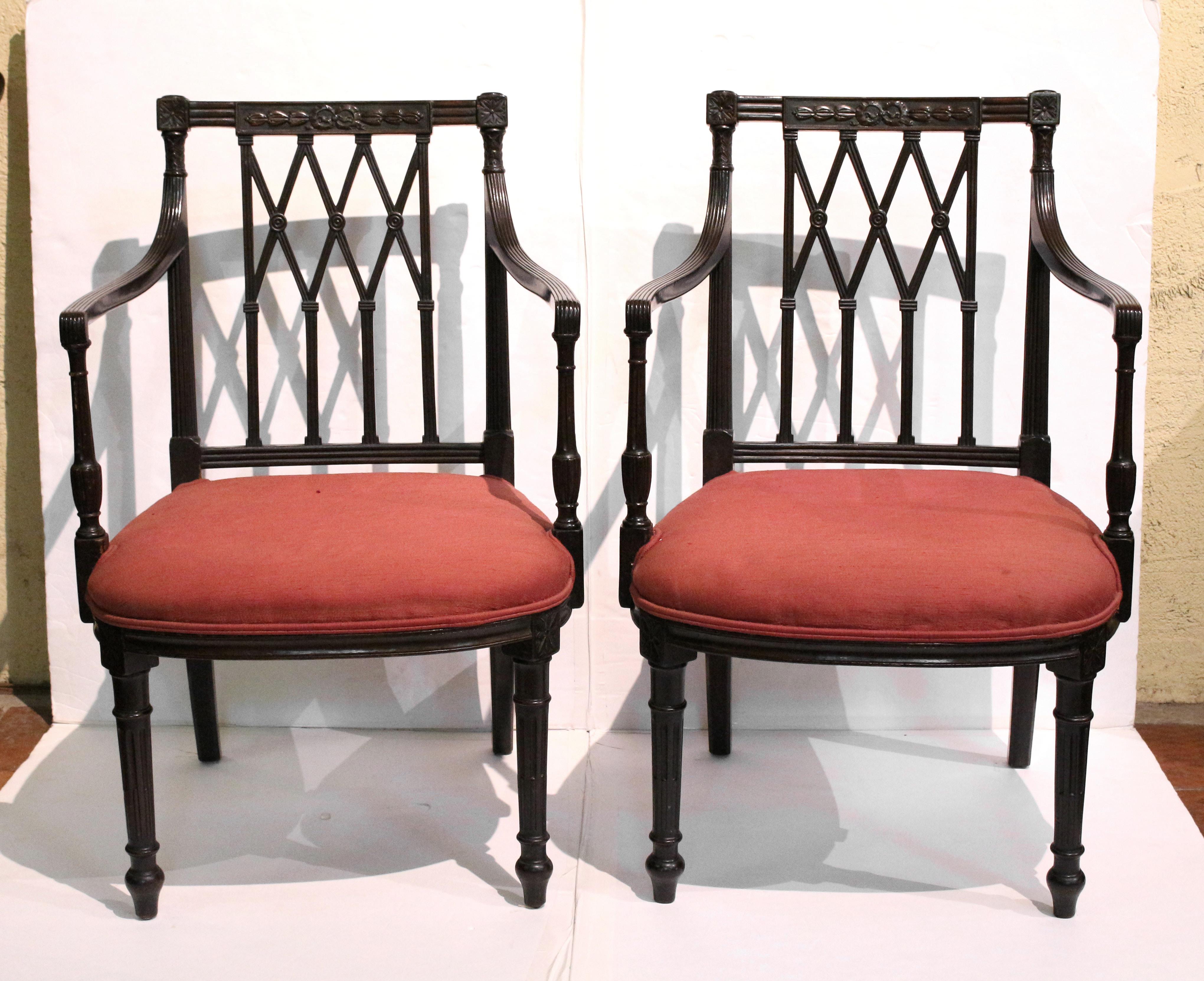 Mid-19th century pair of late Classical arm chairs. English. Mahogany with oak secondary wood. Straight ribbon carved & molded crest rails. Square carved rosettes over the arms to turned acanthus carving to reeded outswept arms & uprights to