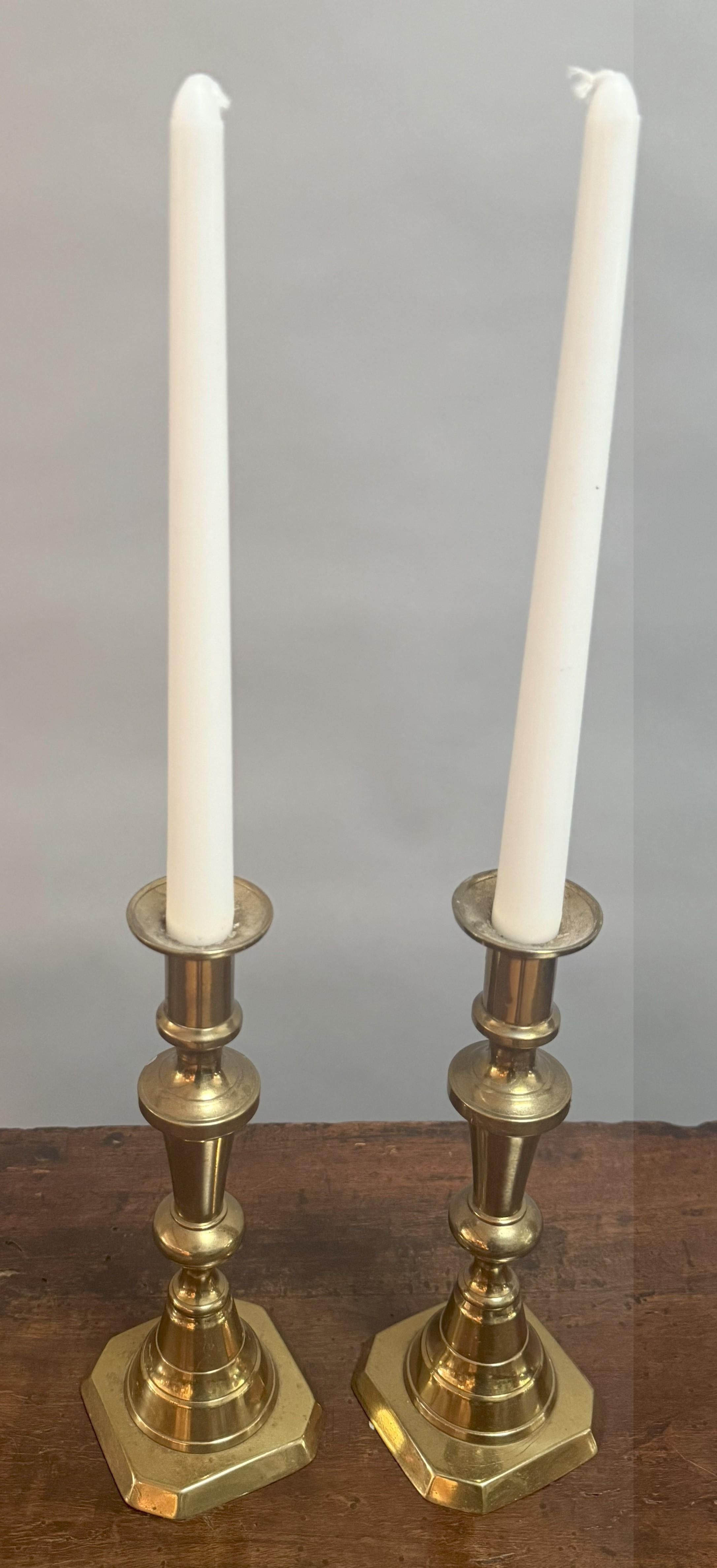 Una raffinata coppia di candelieri inglesi della metà del XIX secolo, splendidamente realizzati in ottone massiccio con steli scultorei e torniti e basi ottagonali ben proporzionate. Il loro design incarna la tranquilla eleganza delle arti