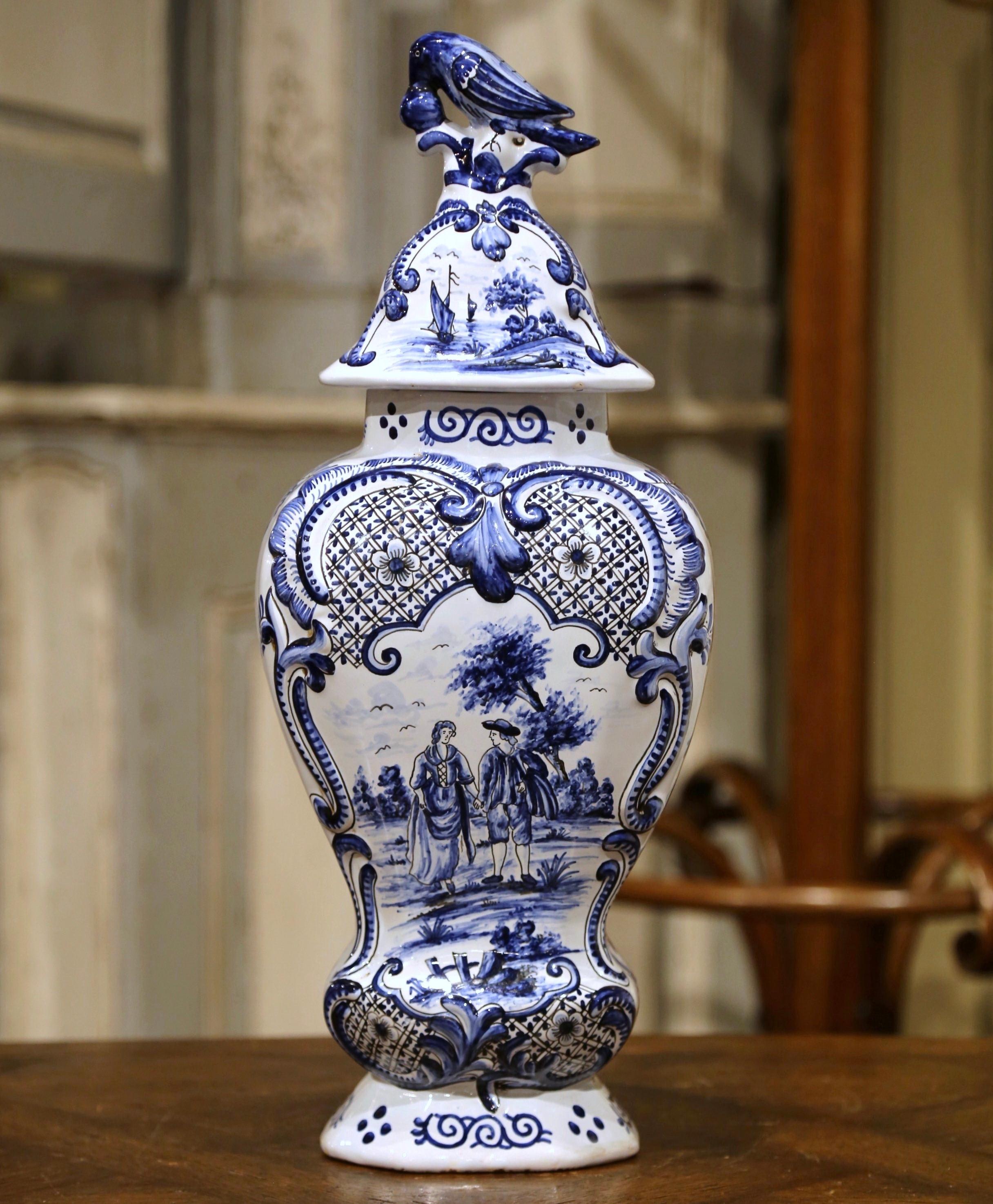 This Classic blue and white Delft vases were created in France, circa 1860. Each porcelain jar is decorated with finely painted, romantic scene medallions and embellished with floral decor in high relief. Each lid is embellished with a sculpted bird