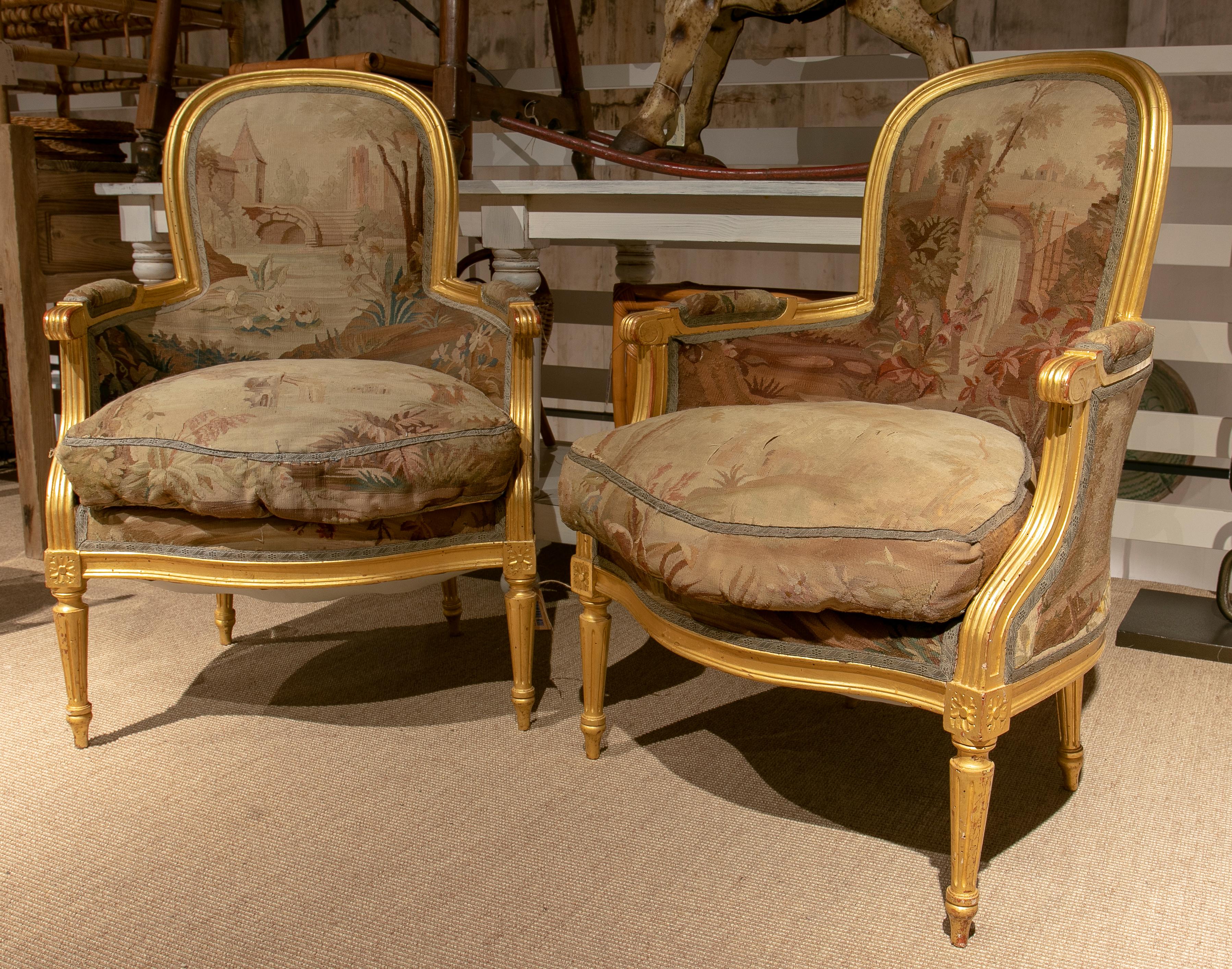 Pair of 1850s French giltwood armchairs w/ 18th century petit point upholstery. 

We think that the upholstery belonged to an earlier pair of armchairs and in the mid 19th century they rebuilt the wooden structure and reused the fabric.