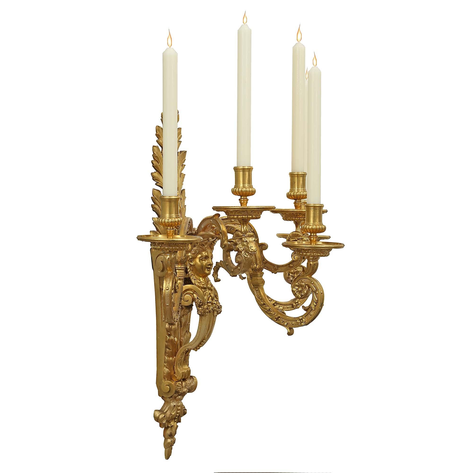 An impressive large scale pair of mid 19th century French Louis XIV st. ormolu five arm sconces. The richly chased pair with all original gilt has a back plate decorated by large acanthus leaves, and a central female figure with her hair braided