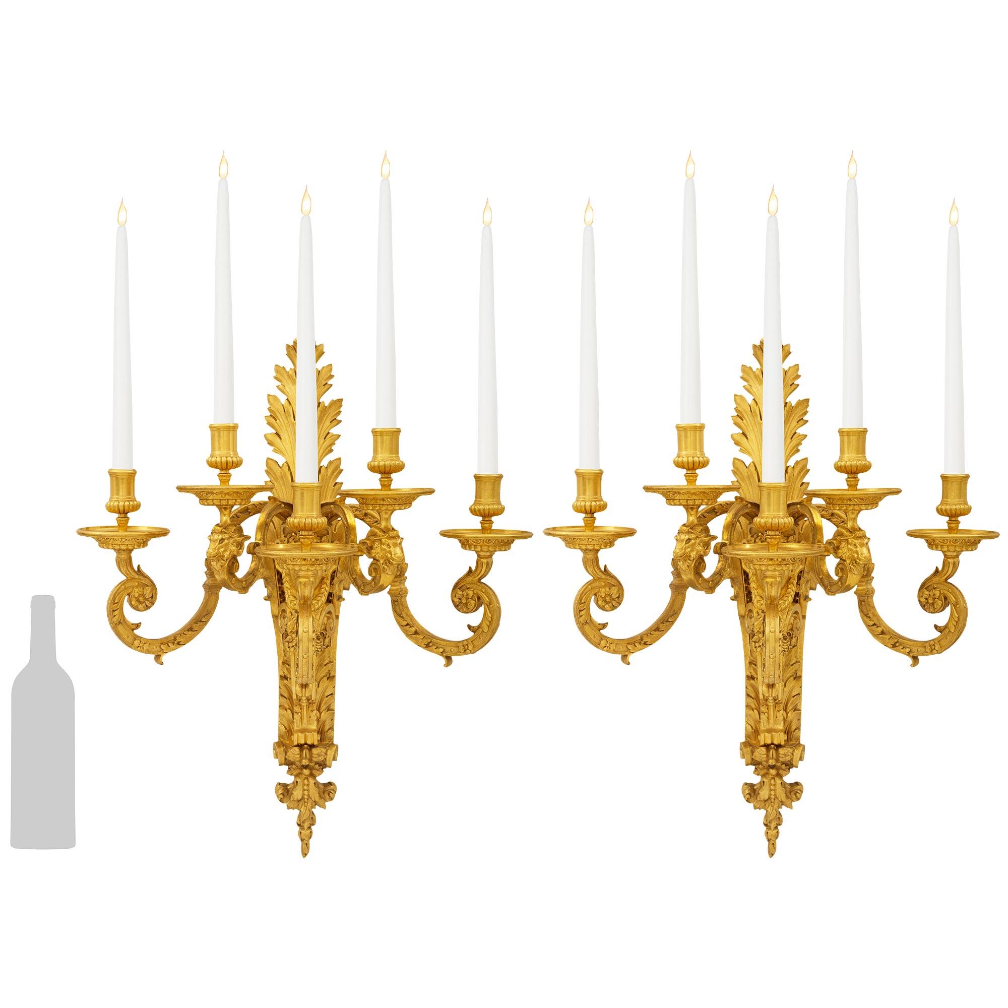 Una coppia impressionante e di grandi dimensioni di appliques francesi della metà del XIX secolo in stile Luigi XIV. Ciascuna applique in Ormolu riccamente cesellato è posta su una piastra posteriore molto decorata da grandi foglie d'acanto e da una
